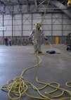 A firefighter pulls rope across the wing of a C-130 to help with lowering the victim down during a simulated confined space exercise Aug. 1 at Duke Field.  Maintainers and firefighters participated in the simulated accident and response exercise.  Evaluators watched to ensure the proper steps are known and taken in the case of an emergency.  (U.S. Air Force photo/Staff Sgt. Samuel King Jr.)