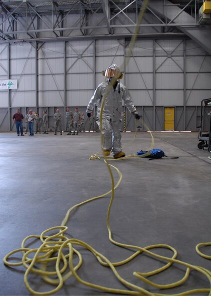 A firefighter pulls rope across the wing of a C-130 to help with lowering the victim down during a simulated confined space exercise Aug. 1 at Duke Field.  Maintainers and firefighters participated in the simulated accident and response exercise.  Evaluators watched to ensure the proper steps are known and taken in the case of an emergency.  (U.S. Air Force photo/Staff Sgt. Samuel King Jr.)