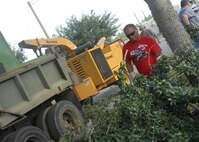 Sergio Lopez, 796th Civil Engineer Squadron, lifts up a branch to take it to the wood chipper after being trimmed Aug. 1 at Duke Field.  (U.S. Air Force photo/Staff Sgt. Samuel King Jr.)