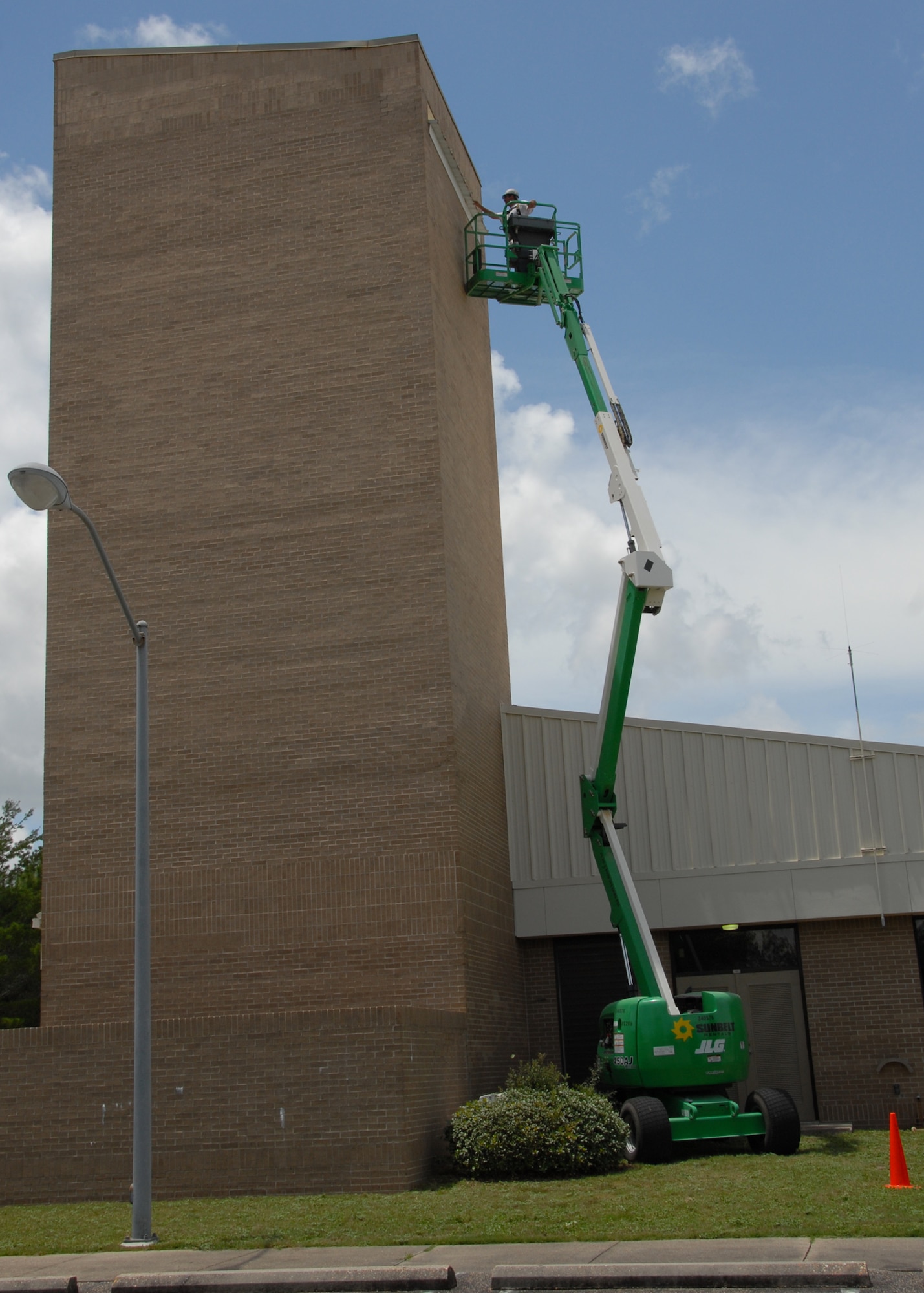 A raised lift stretches up the parachute shop allowing painters from Washington Painting to paint the top of the building.  (U.S. Air Force photo/Staff Sgt. Samuel King Jr.)