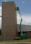 A raised lift stretches up the parachute shop allowing painters from Washington Painting to paint the top of the building.  (U.S. Air Force photo/Staff Sgt. Samuel King Jr.)