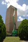 A raised lift stretches up the parachute shop allowing painters from Washington Painting to paint the top of the building.  (U.S. Air Force photo/Staff Sgt. Samuel King Jr.)