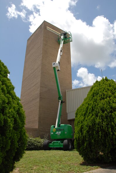 A raised lift stretches up the parachute shop allowing painters from Washington Painting to paint the top of the building.  (U.S. Air Force photo/Staff Sgt. Samuel King Jr.)