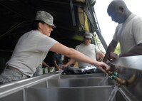 (Left) Staff Sgt. Lucinda Valdez and Master Sgt. Ike Kenty, 919th Services Flight, test the water lines in the kitchen tent Aug. 1 after building the tent for a deployment training exercise.   Services members built two tents to be used as a kitchen and dining facility as part of their training.  The building was plagued by frequent thunderstorms that popped up throughout the process.  Personnel prepared and ate a meal from the tents Aug. 1 during the UTA weekend.  (U.S. Air Force photo/Staff Sgt. Samuel King Jr.)