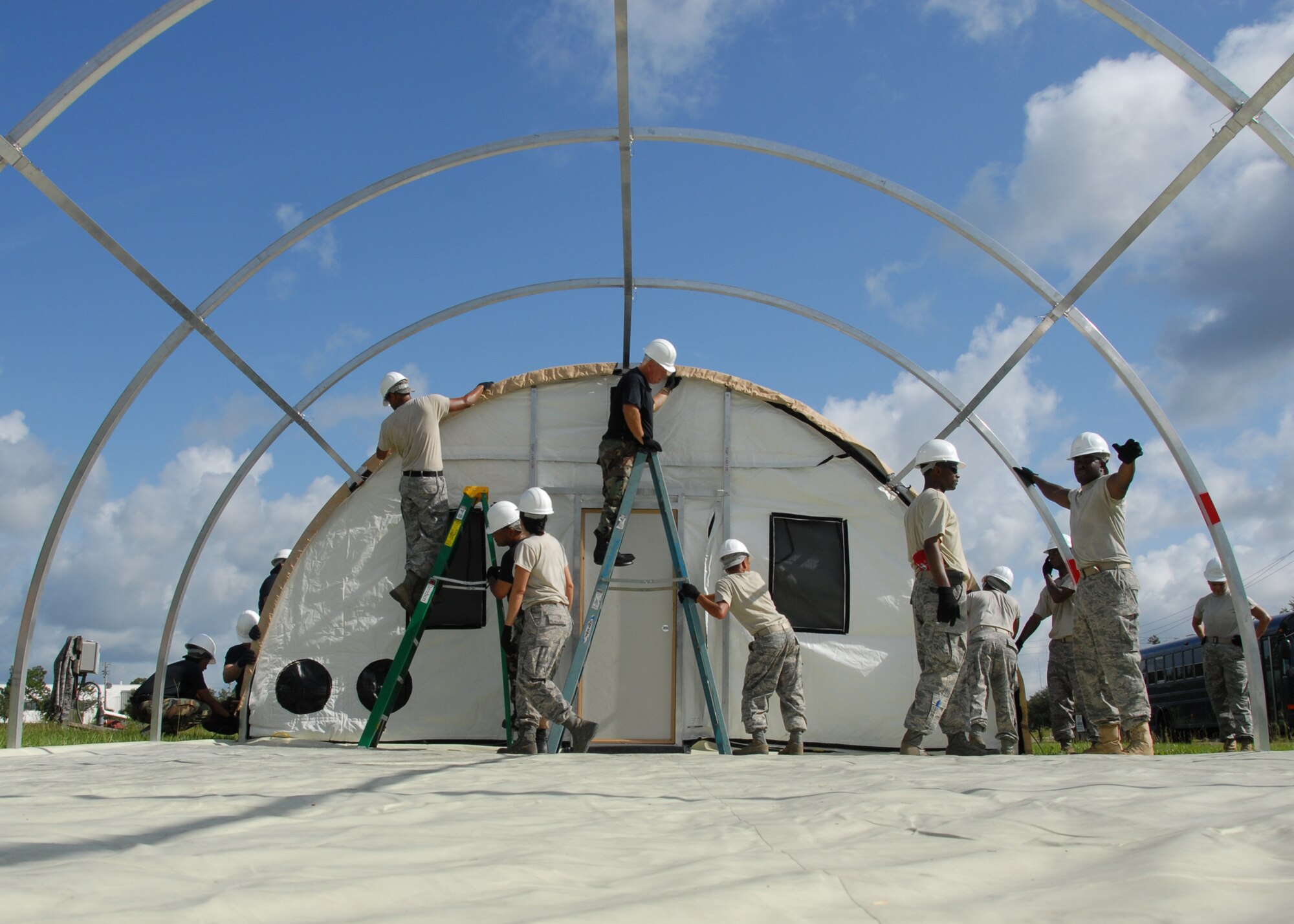 Members of the 919th Services Flight build a tent for a deployment training exercise July 30 at Duke Field.  Services members built two tents to be used as a kitchen and dining facility as part of their training.  The building was plagued by frequent thunderstorms that popped up throughout the process.  Personnel prepared and ate a meal from the tents Aug. 1 during the UTA weekend.  (U.S. Air Force photo/Staff Sgt. Samuel King Jr.)