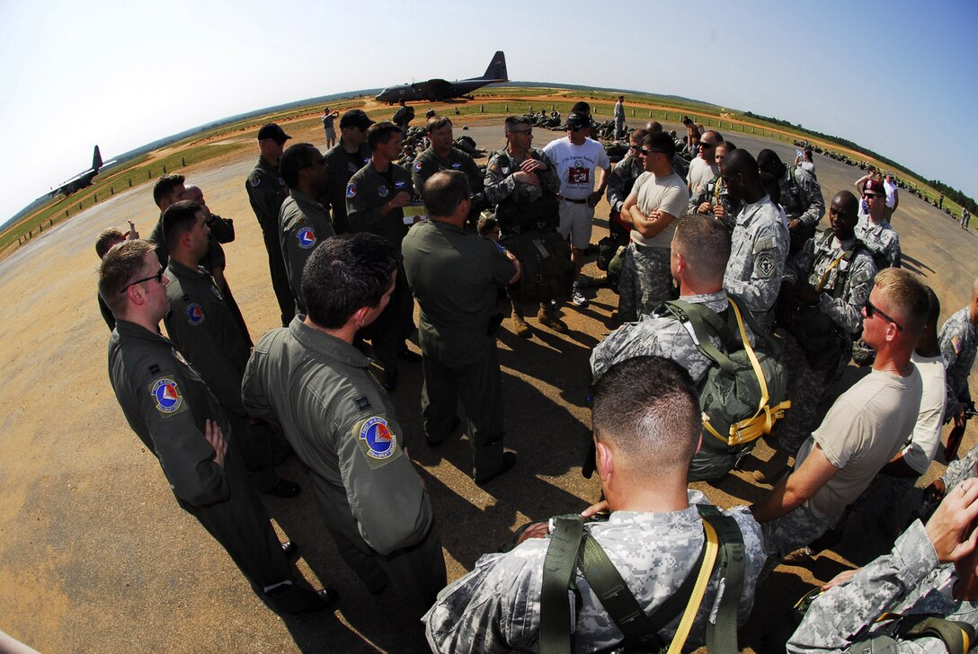Airman assigned to the 156th Airlift Squadron and soldiers assigned to the 18th Airborne Corp, 612th Quarter Master Company have a meeting of the minds before loading. The paratroopers are jumping for a D-Day reinactment over the Sicily Landing Zone, Fort Bragg, N.C. Released Photo by Staff Sgt. Richard M. Kerner, N.C. Air National Guard