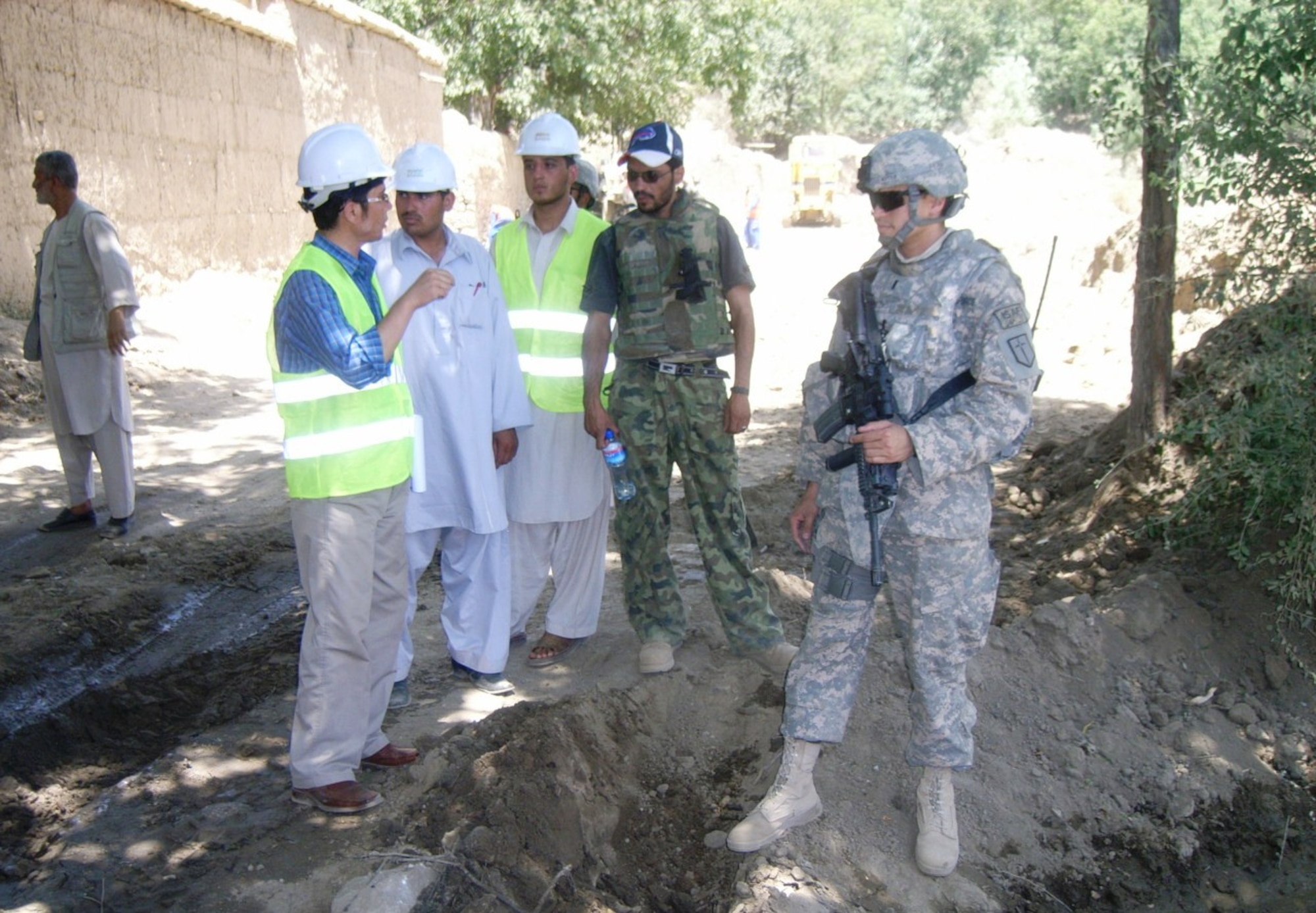 BAGRAM AIRFIELD, Afghanistan - U.S. Air Force 1st Lt. Graham Auten of the Kapisa and Parwan PRT discusses construction of the Farukh Shah Road with local Afghan workers in the Nijrab district of Kapisa province, Afghanistan, July 27. (U.S. Air Force photo/1st Lt. Anthony Raffaele)
