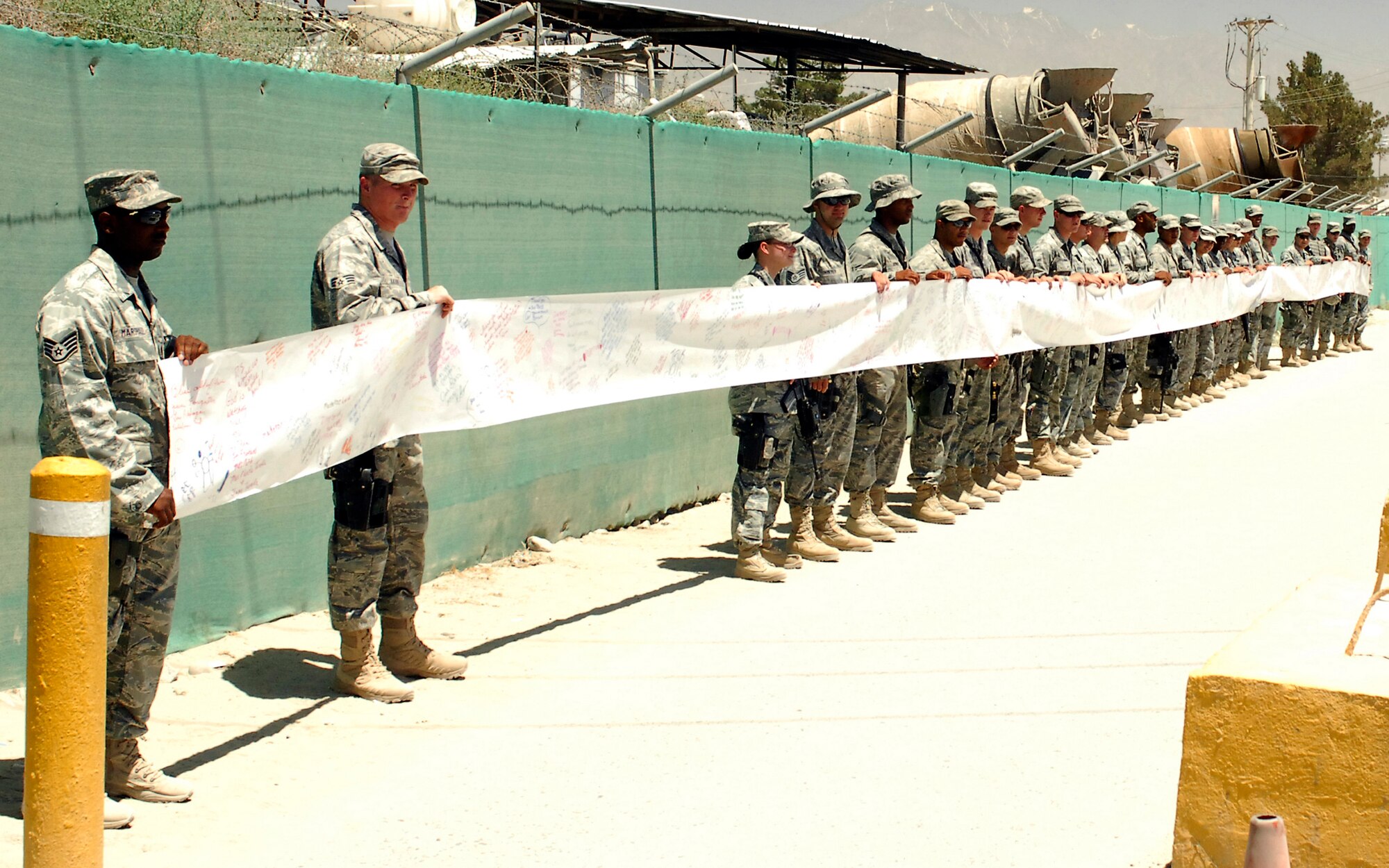 BAGRAM AIRFIELD, Afghanistan - Members of the 455th Expeditionary Security Forces Squadron hang a 480ft. and two inch banner, from Md., to boost morale of the troops, here July 31. (U.S. Air Force photo/Senior Airman Felicia Juenke)
