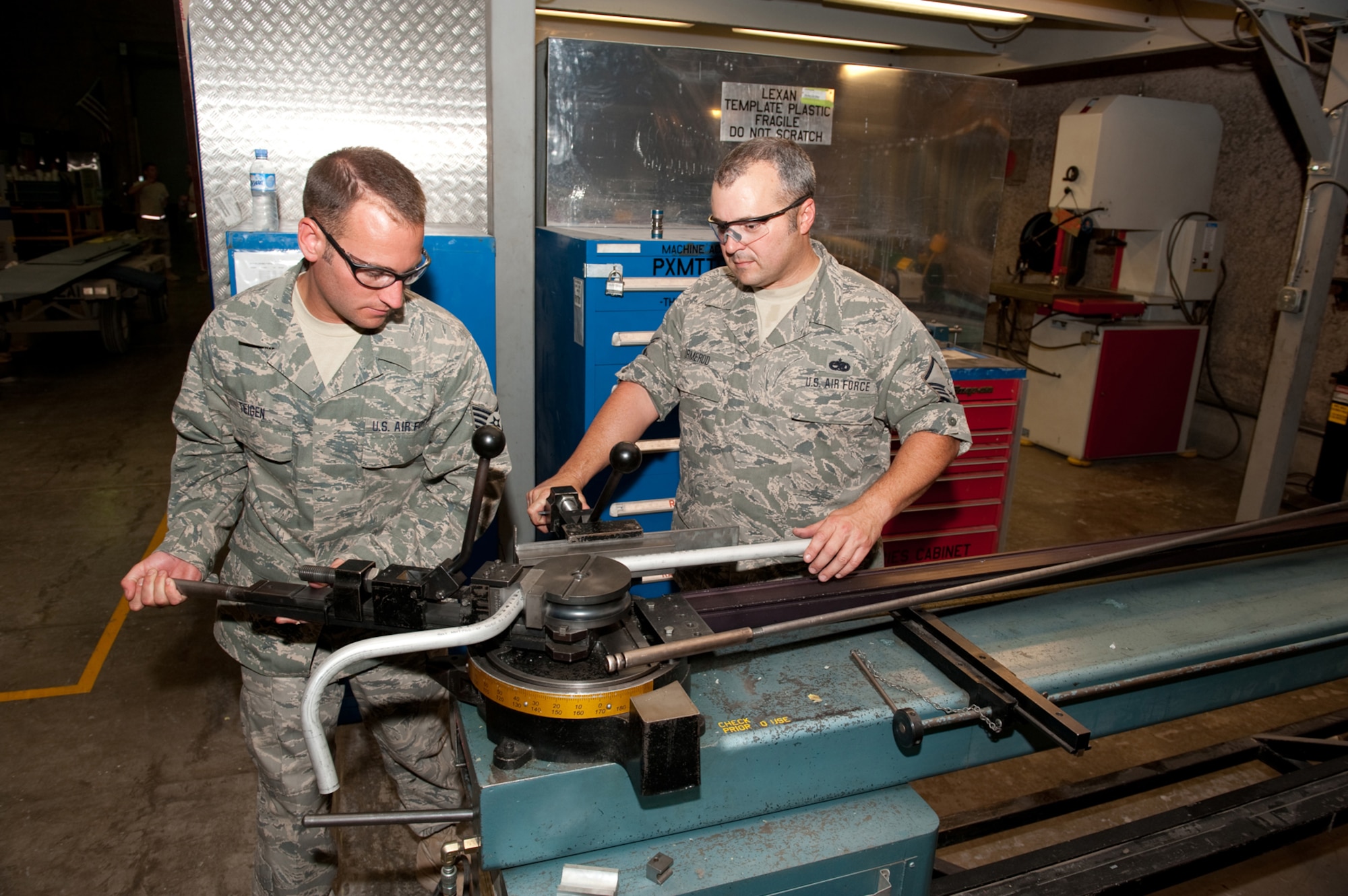 Left, Staff Sgt. Andrew Teigen and Master Sgt. Michael Ormerod, aircraft structural maintainers from the 379th Expeditionary Maintenance Squadron, bend tubing for aircraft hydraulic line use, July 27, in Southwest Asia. Sergeant Teigen is a native of Casselton, N.D. and deployed from the 119th Wing, North Dakota Air National Guard.  Sergeant Ormerod is a native of Dallas, Texas and is deployed from the 161st Air Refueling Wing, Arizona Air National Guard. Both are serving in support of Operations Iraqi and Enduring Freedom. (U.S. Air Force Photo/Staff Sgt. Robert Barney)