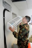 ELMENDORF AIR FORCE BASE, Alaska -- Airman Richard Giglio lifts an air conditioning evaporator into place July 28. The split system air conditioning unit is one of the many units used on base to aid the mission. Giglio is a member of the 3rd Civil Engineer Squadron. (U.S. Air Force photo/Airman Jack Sanders)