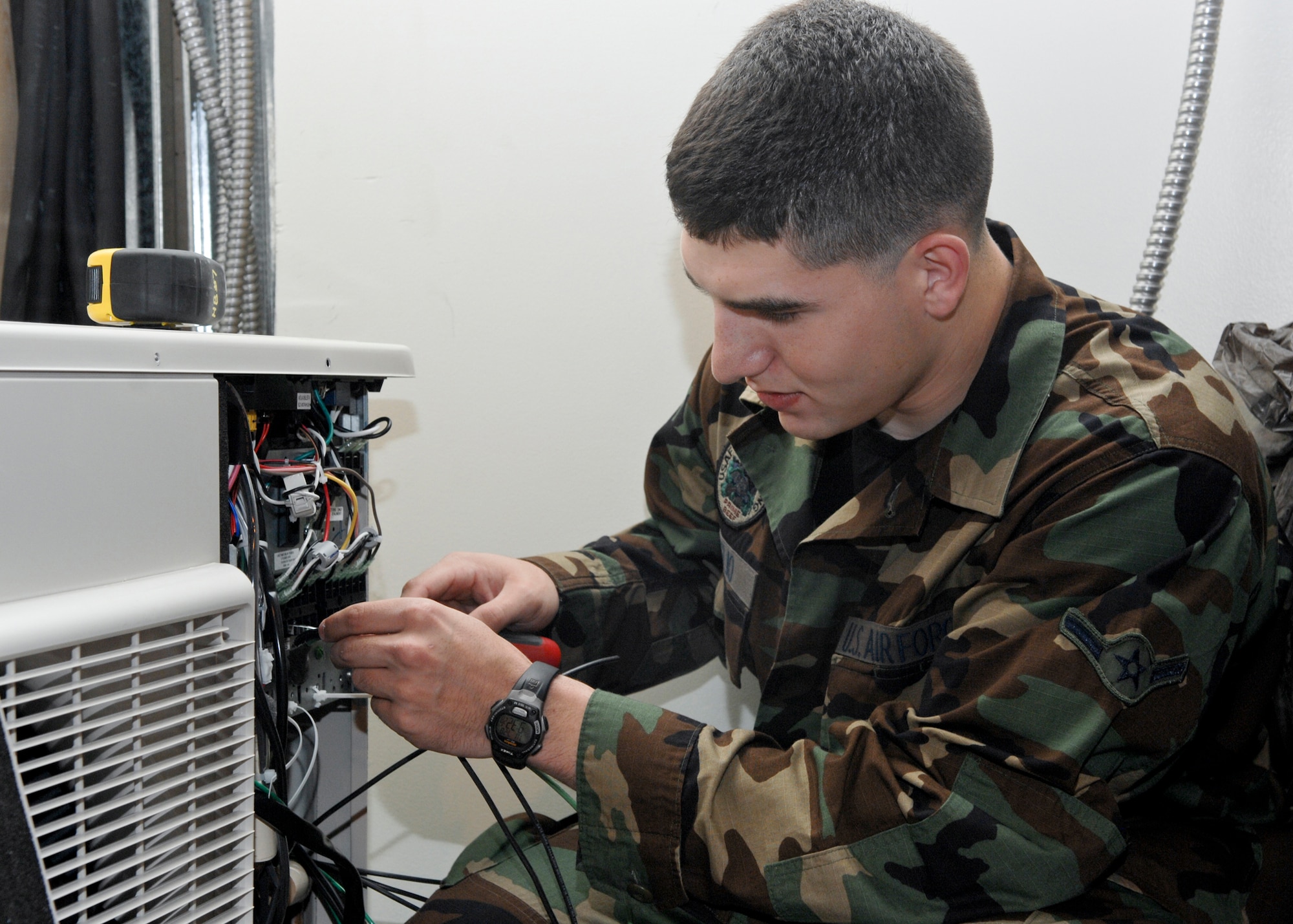 ELMENDORF AIR FORCE BASE, Alaska -- Airman Richard Giglio works on an air conditioning while installing a split system air conditioning unit. The split system air conditioning unit is one of the many units used on base to aid the mission. Giglio is a member of the 3rd Civil Engineer Squadron. (U.S. Air Force photo/Airman Jack Sanders)