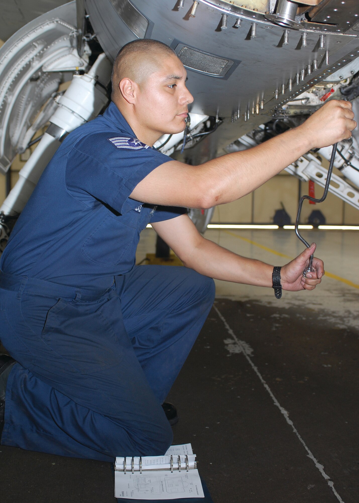 Staff Sgt. Joseph Salazar, 56 Equipment Maintenance Squadron crew chief, loosens screws on the clam shell door of an F-16 at the phase dock at Luke AFB. (U.S. Air Force photo by Senior Airman Tracie Forte)