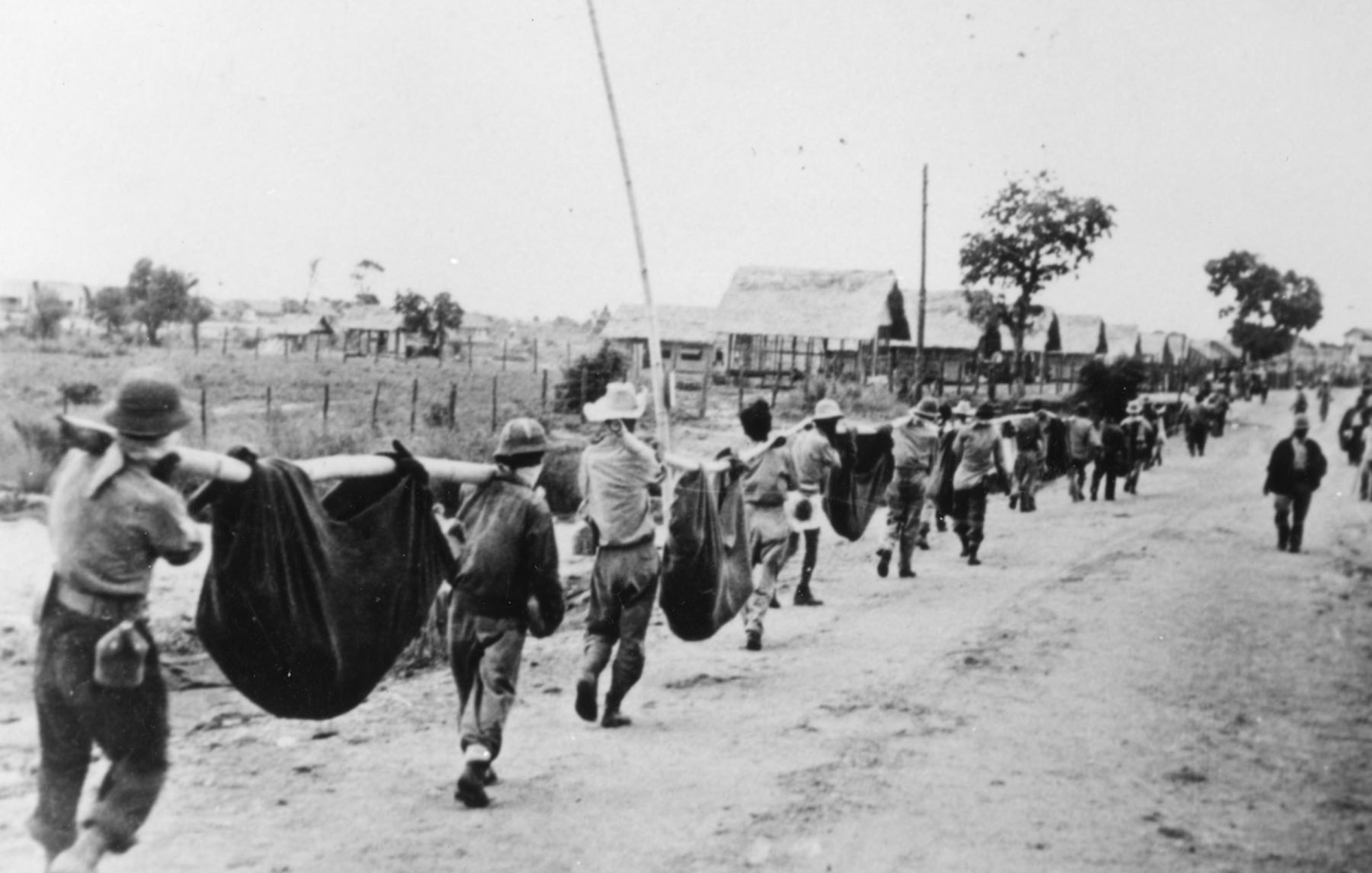 A burial detail carries the remains of POWs who survived the Death March, but who later succumbed to exhaustion, disease, or execution after reaching Camp O'Donnell. (U.S. Air Force photo).