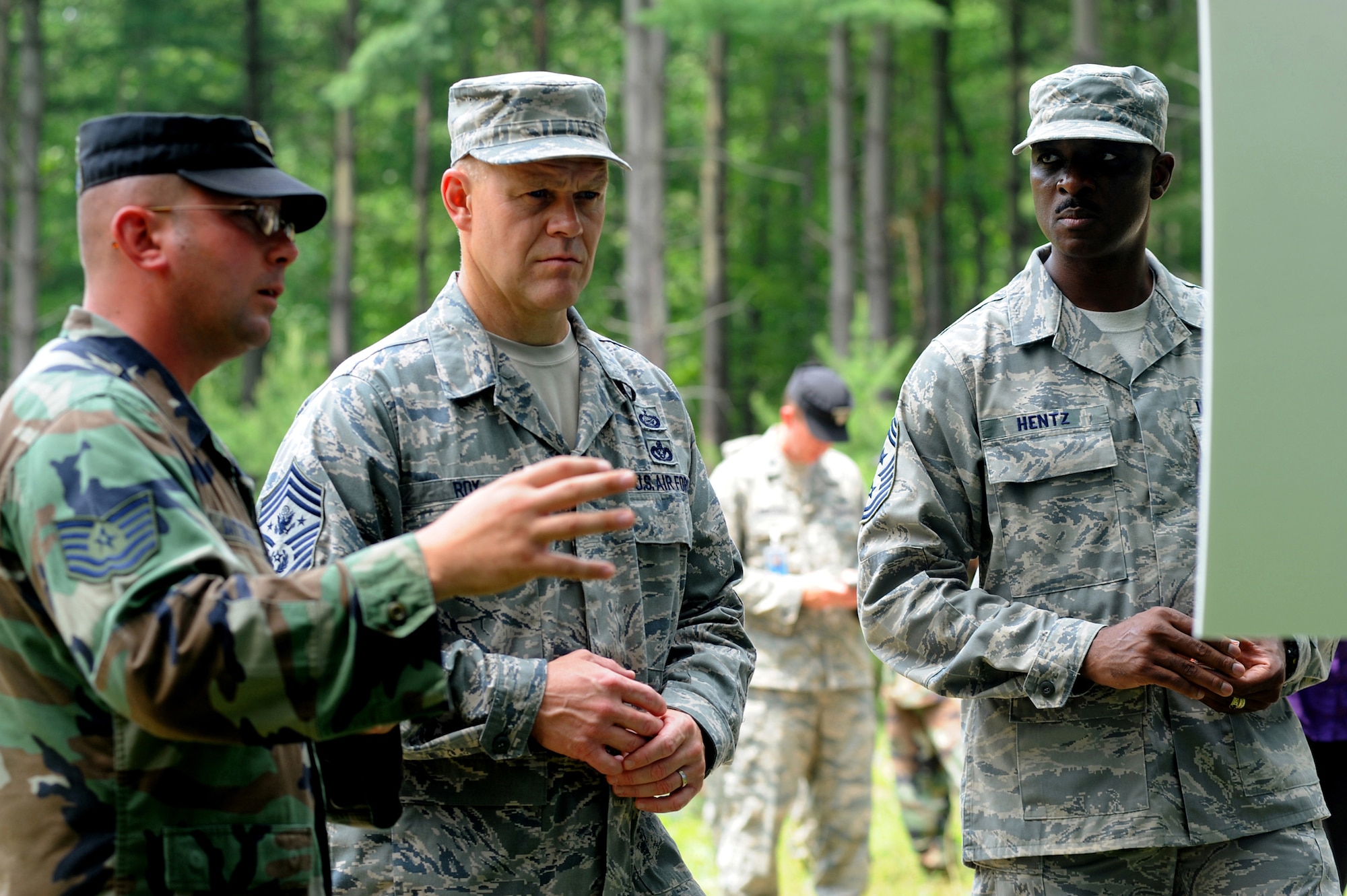Technical Sgt. Donald Satterlee, from the U.S. Air Force Expeditionary Center's 421st Combat Training Squadron, briefs Chief Master Sgt. of the Air Force James Roy about Advanced Contingency Skills Training for Airmen while Chief Master Sergeant Fitzgerald Hentz, U.S. Air Force Expeditionary Center command chief, listens.  Part of the July 29 tour took place on a Fort Dix range on Joint Base McGuire-Dix-Lakehurst, N.J.  Chief Roy visited the U.S. Air Force Expeditionary Center on Fort Dix and McGuire Air Force Base to learn more about expeditionary training and operations in both areas. (U.S. Air Force Photo/Staff Sgt. Nathan G. Bevier) 