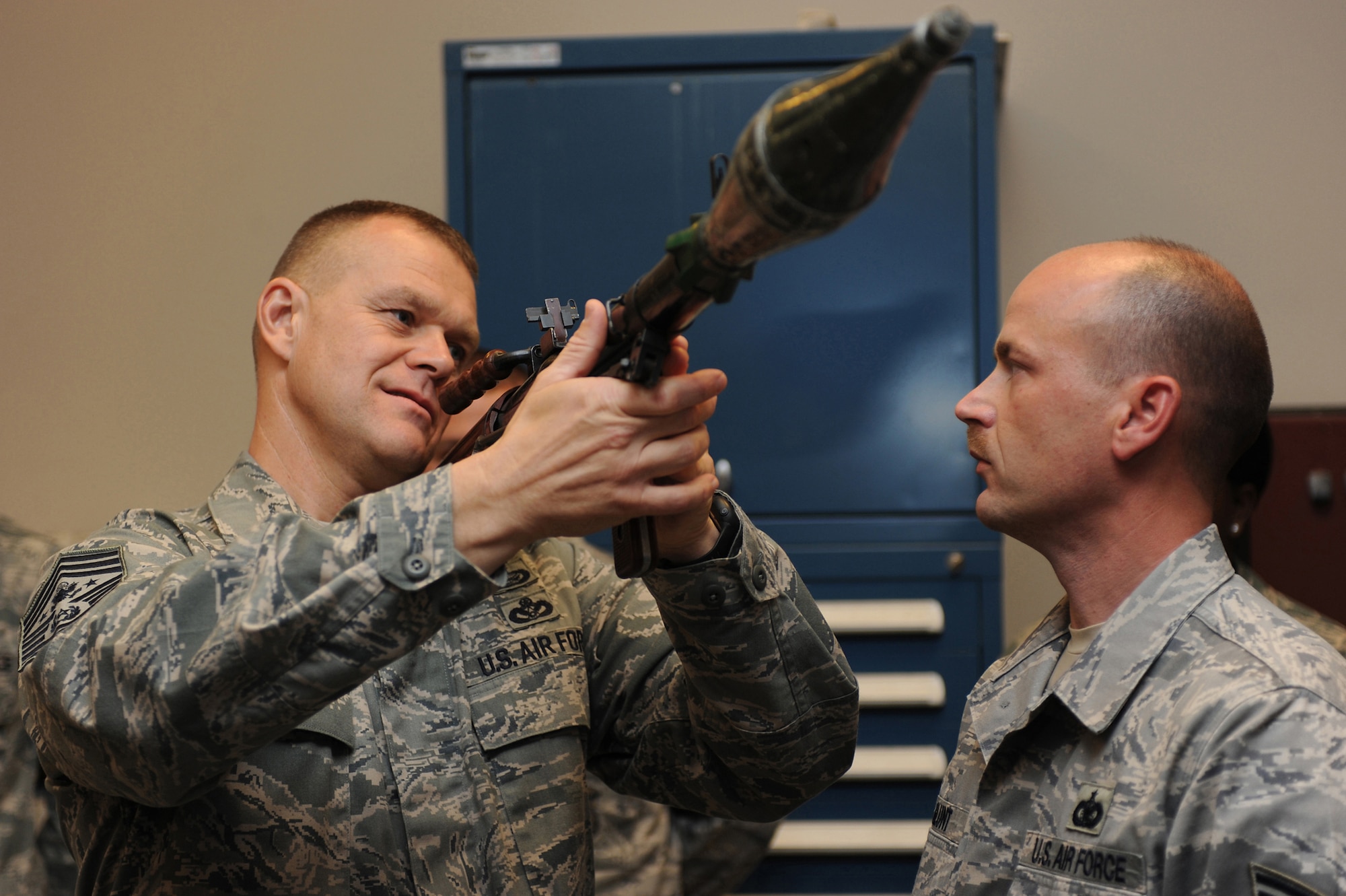Chief Master Sgt. of the Air Force James Roy examines a demonstration weapon as Technical Sgt. Charles Glunt, from the U.S. Air Force Expeditionary Center armory, shows how to use it during a July 29 tour at the Expeditionary Center on the Fort Dix section of Joint Base McGuire-Dix-Lakehurst, N.J.  Chief Roy visited the U.S. Air Force Expeditionary Center on Fort Dix and McGuire Air Force Base to learn more about expeditionary training and operations in both areas. (U.S. Air Force Photo/Staff Sgt. Nathan G. Bevier) 