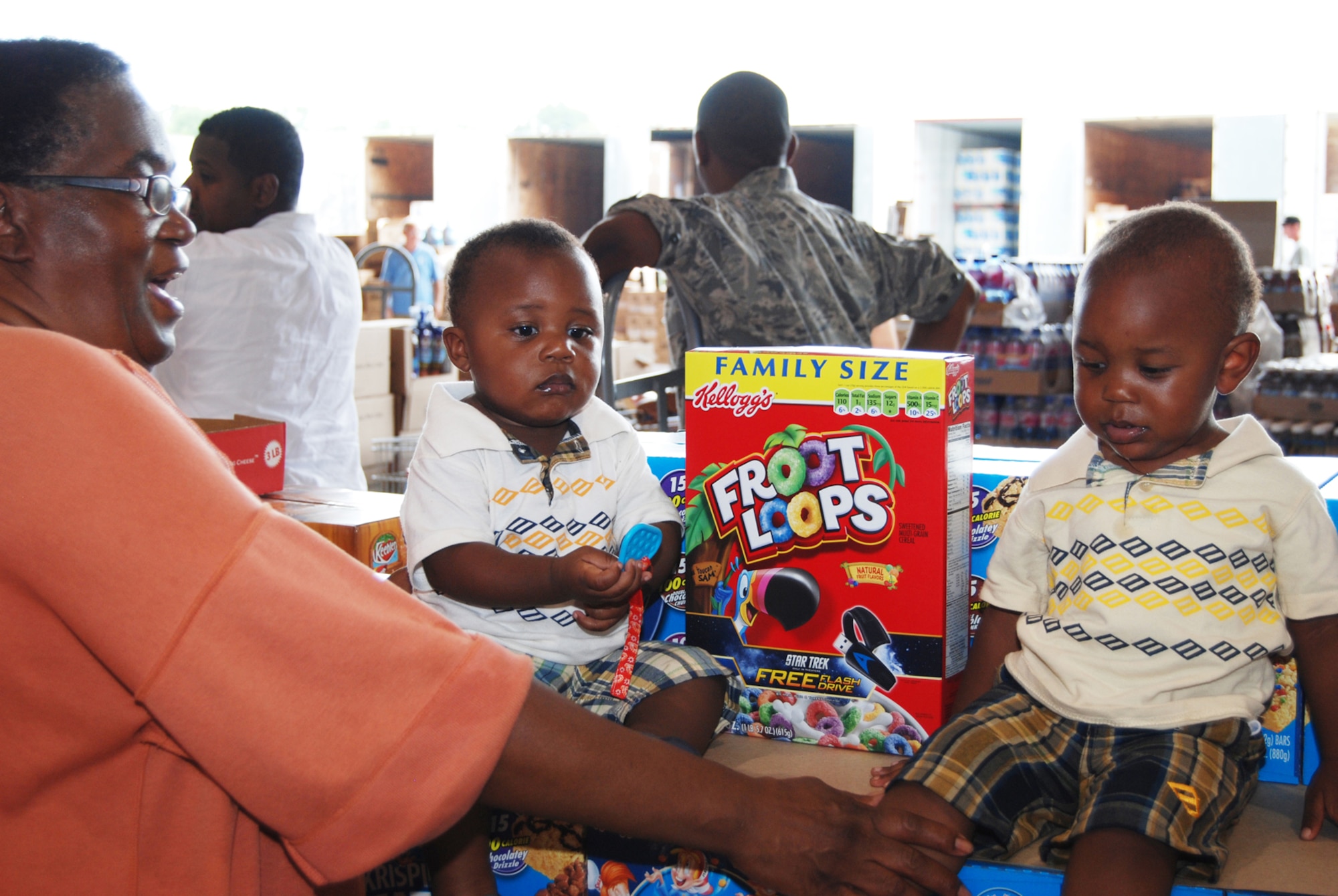 Twins Miller Cole Watkins and Maxwell Watkins help their grandmother shop for good deals on cereals at the Case Lot Sale July 31 inside Hangar 5. The sale is held every quarter and offers discounted groceries to retirees and current Airmen. (U.S. Air Force Photo/Senior Airman Quadoah Ford)