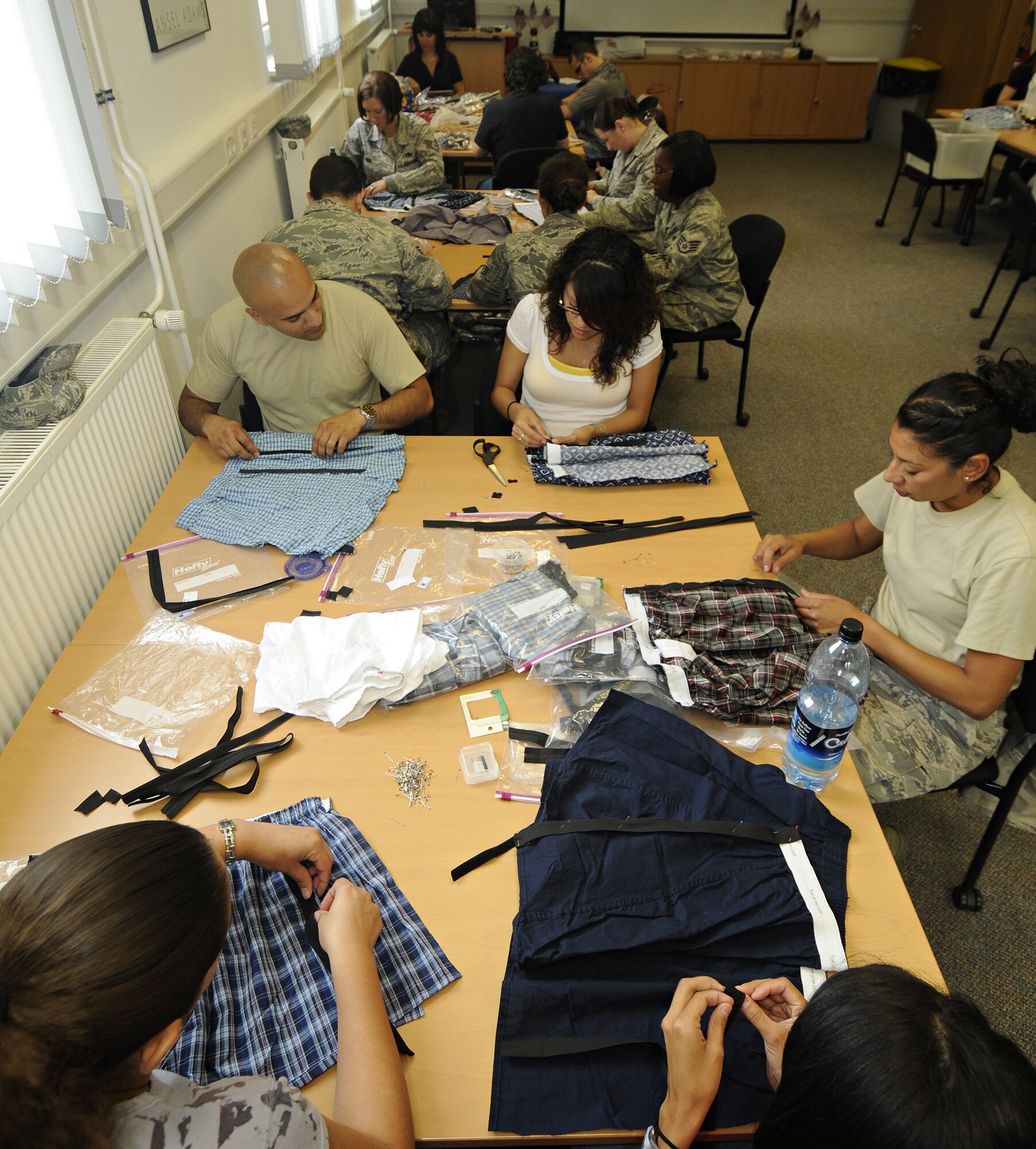 SPANGDAHLEM AIR BASE, Germany -Spangdahlem Air Base people work to adapt boxers while volunteering for "Sew Much Comfort" July 31. Twenty-five volunteers worked from 9:30 a.m. to 2:30 p.m. to assemble 60 pairs of boxers while 22 pairs were completed. Since the program started in October 2008 more than 150 pairs of boxers have been completed to send to Landstuhl Regional Medical Center's chaplain's closet, where they will be available to wounded warriors.  (U.S. Air Force photo by Senior Airman Benjamin Wilson)