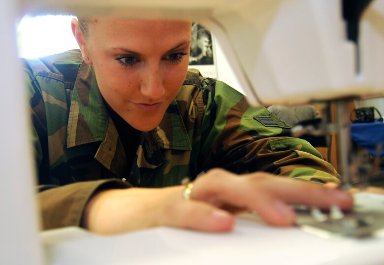SPANGDAHLEM AIR BASE, Germany - Airman 1st Class Morgan Campbell, 52nd Logistics Readiness Squadron, prepares a sewing machine for modifying boxer shorts while volunteering for "Sew Much Comfort" July 31. Twenty-five volunteers worked from 9:30 a.m. to 2:30 p.m. to assemble 60 pairs of boxers while 22 pairs were completed. Since the program started in October 2008 more than 150 pairs of boxers have been completed to send to Landstuhl Regional Medical Center's chaplain's closet, where they will be available to wounded warriors.  (U.S. Air Force photo by Senior Airman Benjamin Wilson)