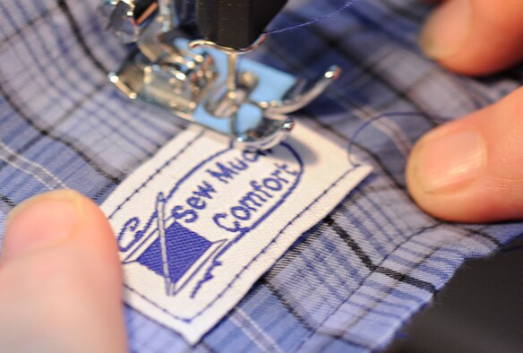 SPANGDAHLEM AIR BASE, Germany -- Karen Bortner, 52nd Fighter Wing Chapel Resource Center, sews the signature patch of "Sew Much Comfort" into a pair of boxer shorts July 31. Twenty-five volunteers worked from 9:30 a.m. to 2:30 p.m. to assemble 60 pairs of boxers while 22 pairs were completed. Since the program started in October 2008 more than 150 pairs of boxers have been completed to send to Landstuhl Regional Medical Center's chaplain's closet, where they will be available to wounded warriors.  (U.S. Air Force photo by Senior Airman Benjamin Wilson)