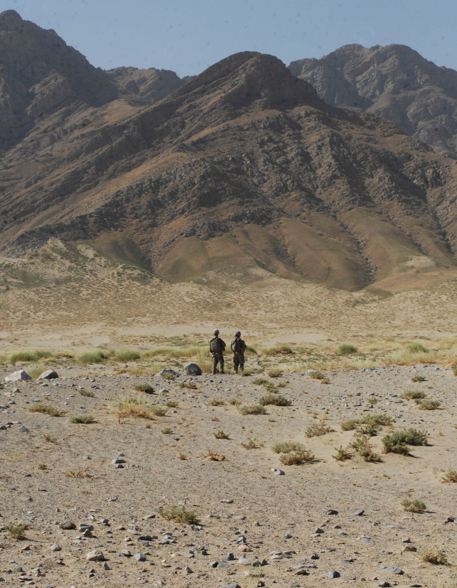 BAGRAM AIRFIELD, Afghanistan - Against the backdrop of mountains in Afghanistan, two soldiers from Combined Joint Task Force-82 provide security for the 755th Air Expeditionary Group's Explosive Ordnance Disposal flight. The EOD technicians disposed of several hundreds of pounds of explosives, including discarded Soviet munitions from the 1970s on Aug. 2. (U.S. Air Force photo/Tech. Sgt. John Jung)