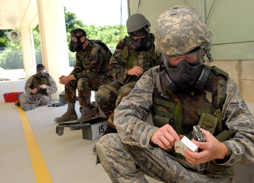 Airmen don their gas masks at the Combat Arms Training and Maintenance to be augmentees for the 18th Security Forces July 29 at Kadena Air Base, Japan. The Airmen go through a set 3-day course consisting of weapons firing, classroom instruction of SF responsibilities, and hands-on training made up of searching, handcuffing, and challenging individuals and vehicles. 
(U.S. Air Force photo/Tech. Sgt. Rey Ramon)         