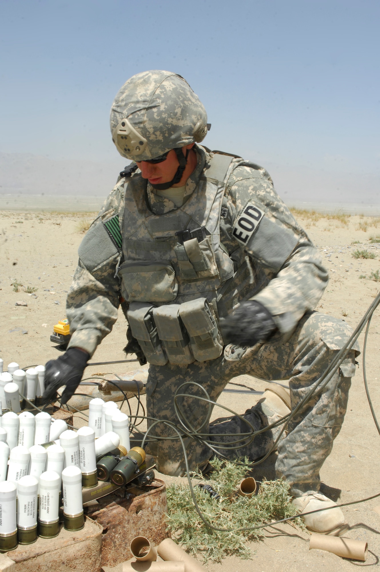 BAGRAM AIRFIELD, Afghanistan - Staff Sgt. Greg Talley, 755th Air Expeditionary Group, Explosive Ordnance Disposal technician inserts blasting caps into C-4 explosive charges at a ordnance disposal range near BAF. Several hundreds of pounds of mixed ordnance, including discarded Soviet munitions from the 1970s, were disposed of Aug 2. Sergeant Talley is deployed from Dyess Air Force Base, Texas and hails from Rogers, Ark. (U.S. Air Force photo/Tech. Sgt. John Jung)