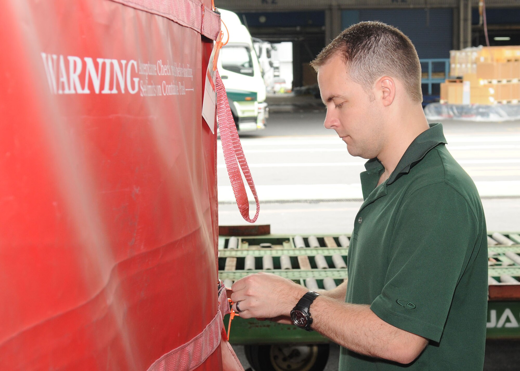 NARITA, Japan -- Tech. Sgt. Dave Edwards, Det. 2 Pacific Air Forces Air Postal Squadron NCO in charge of mail control agents, secures a cart of registered mail July 31 at Narita International Airport. All registered mail is monitored from arrival to take off to ensure its safety. The squadron of 11 military and seven Japanese members handles nearly 30 million pounds of mail each year for all of mainland Japan. Mail flown in from all over the world is trucked to various installations throughout the Kanto Plain.  (U.S. Air Force photo/Airman First Class Sean Martin)