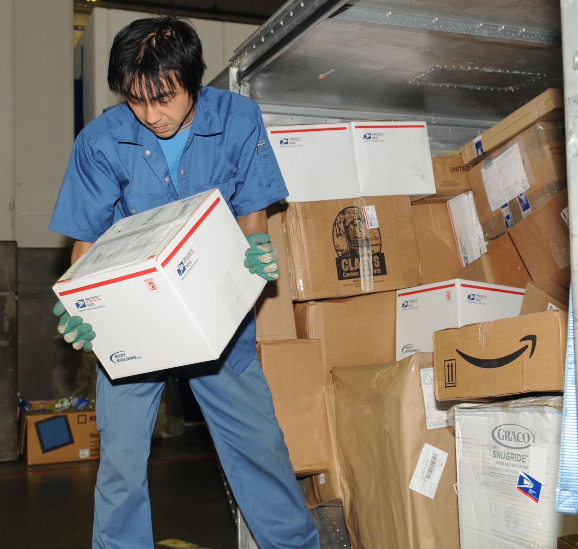 NARITA, Japan -- Sigeharu Kokubun, Det. 2 Pacific Air Forces Air Postal Squadron mail sorting clerk, unloads and sorts a mail cart July 31 at Narita International Airport. The squadron of 11 military and seven Japanese members handles nearly 30 million pounds of mail each year for all of mainland Japan. Mail flown in from all over the world is trucked to various installations throughout the Kanto Plain. (U.S. Air Force photo/Airman 1st Class Sean Martin)