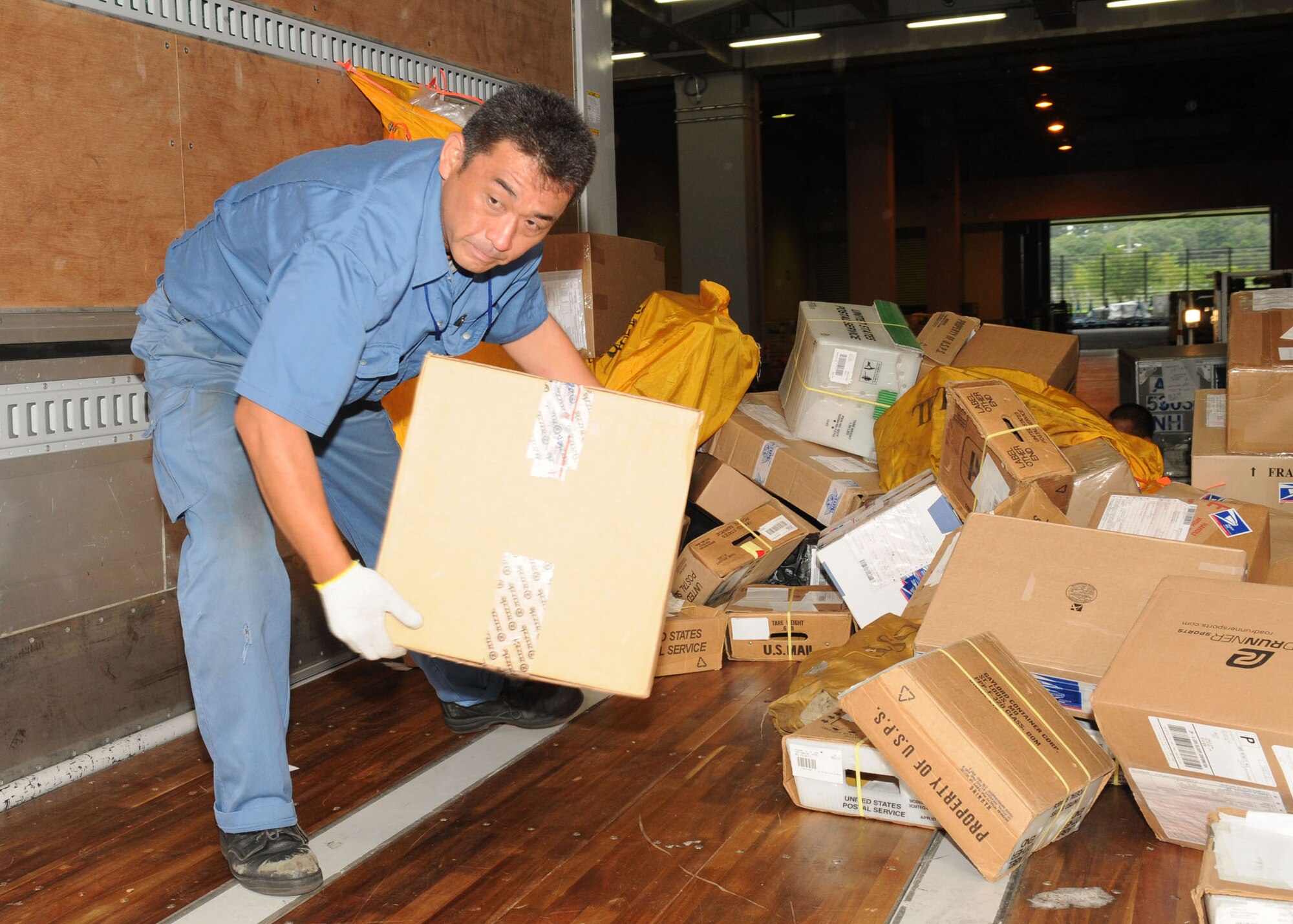 NARITA, Japan -- Tsuneaki Yamada, Det. 2 Pacific Air Forces Air Postal Squadron mail control agent supervisor, loads mail onto a transport truck July 31 at Narita International Airport. The squadron of 11 military and seven Japanese members handles nearly 30 million pounds of mail each year for all of mainland Japan. Mail flown in from all over the world is trucked to various installations throughout the Kanto Plain. (U.S. Air Force photo/Airman 1st Class Sean Martin)