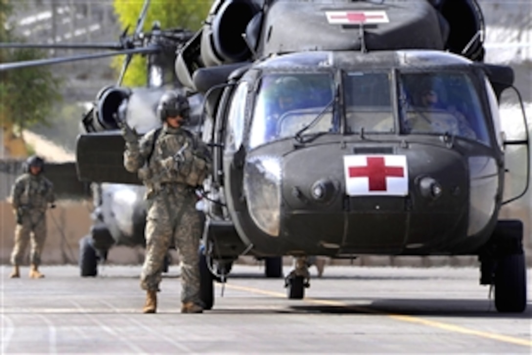 A pair of UH1-H medical evacuation helicopters wait for their crew members to return after dropping off a casualty at a battalion aid station on Forward Operating Base Diamondback, Mosul, Iraq, July 31, 2009. 