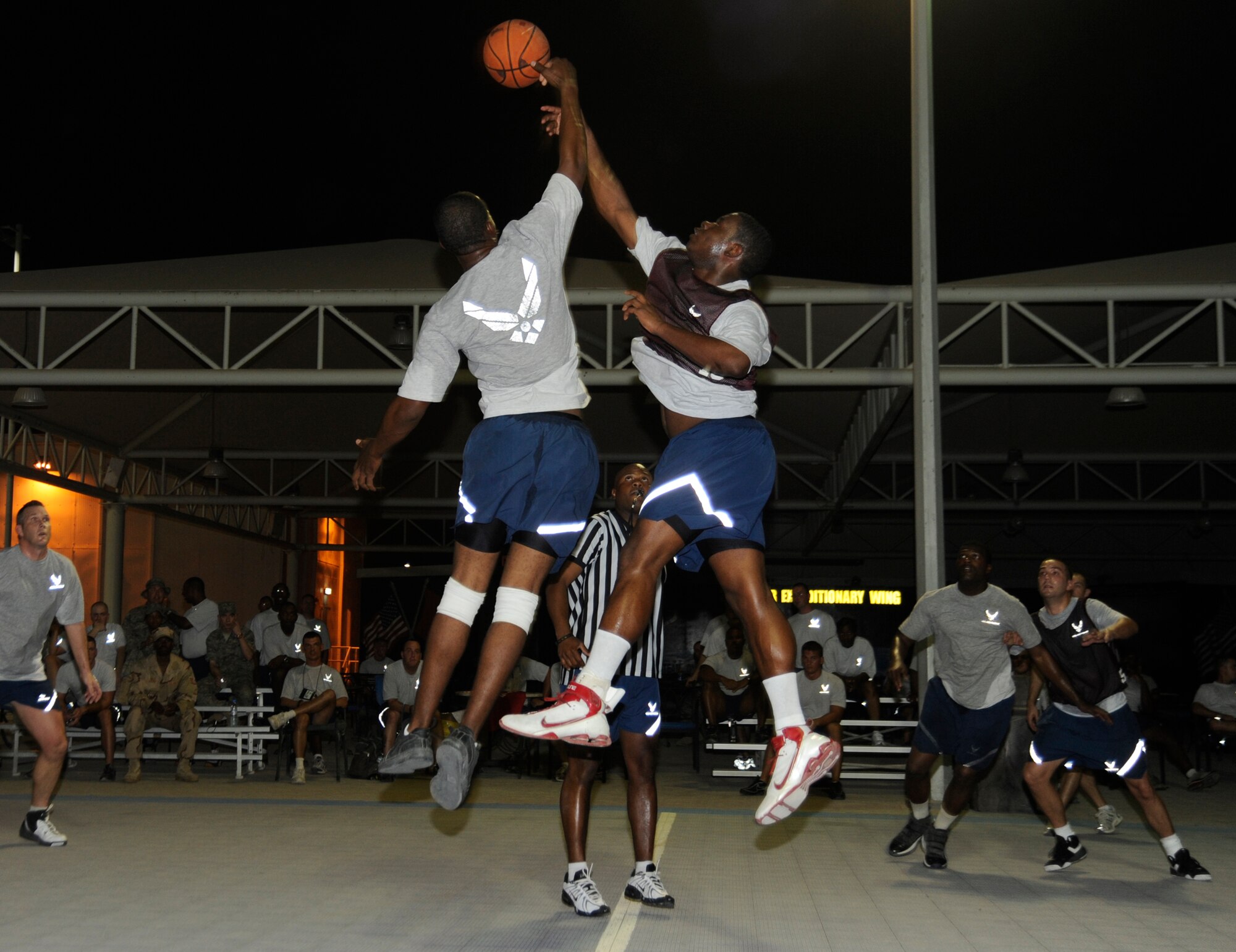 SOUTHWEST ASIA – Senior Airman Sean Cooper, 380th Expeditionary Security Forces, Force Protection Basketball Team, gets the tip over Senior Airman Latavis Johnson, 380th Expeditionary Civil Engineer Squadron, Fire Department Basketball Team, Aug. 4. The Force Protection Team won the game, 35 – 34. (U.S. Air Force photo/Senior Airman Stephen Linch)