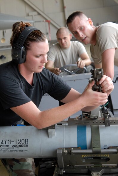 KUNSAN AIR BASE, Republic of Korea -- Staff Sgt. Jennifer Campbell, attaches the AIM-120 to the jammer while driver Senior Airman Spencer Merritt, and Senior Airman Kyle House, all weapons loaders assigned to the 35th Aircraft Maintenance Unit, wait to begin transporting the bomb during a weapons loading competition July 31. Their team is competing against the 80th Aircraft Maintenance Unit in a monthly weapons loading competition to determine which team will represent the 8th Fighter Wing. Sergeant Campbell is a native of Wheatland, Calif., Airman Merritt is a native of Colorado Springs, Co., and Airman House is a native of Troy, Ohio. (U.S. Air Force photo/Staff Sgt. Darnell T. Cannady)