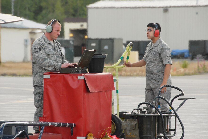 Tech. Sgt. Ernest Kunde, 477th Fighter Group Aircraft Maintenance Squadron,  and Airman 1st Class Juan Leal, 3rd Wing Maintenance Squadron, review forms on the Portable Maintenance Assistance Unit prior to launch during Red Flag-Alaska July 28.  Red Flag-Alaska is a Pacific Air Forces commander-based field training exercise for U.S. coalition forces flown under simulated air combat conditions. It provides joint offensive counter-air, interdiction close air support, and large force employment training in a simulated combat environment.  This is the third Red Flag-Alaska exercise members of the 477th FG have participated in since the group?s activation in 2007, training alongside their active-duty counterparts as part of Total Force Integration.