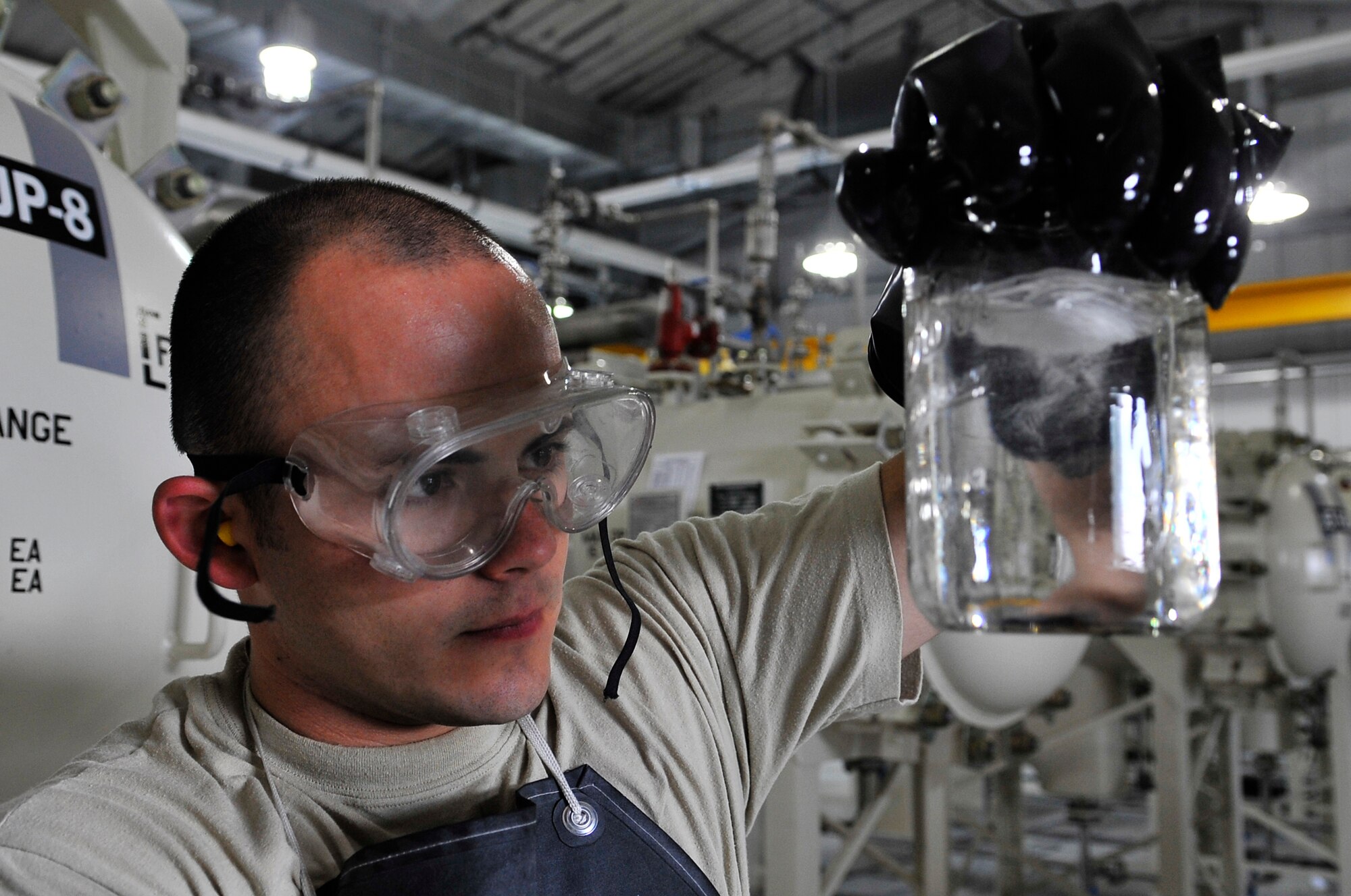 Staff Sgt. Timothy Styers examines jet fuel for particles and water at a fuel pump house during Red Flag-Alaska 09-3 July 31, 2009, Eielson AFB. Jet fuel is transferred through pipes to the pump house where it is pushed to hydrants to different parts of the flightline. Sergeant Styers is assigned to the 354th Logistics Readiness Squadron, fuels management flight.  (U.S. Air Force photo/Staff Sgt. Christopher Boitz)