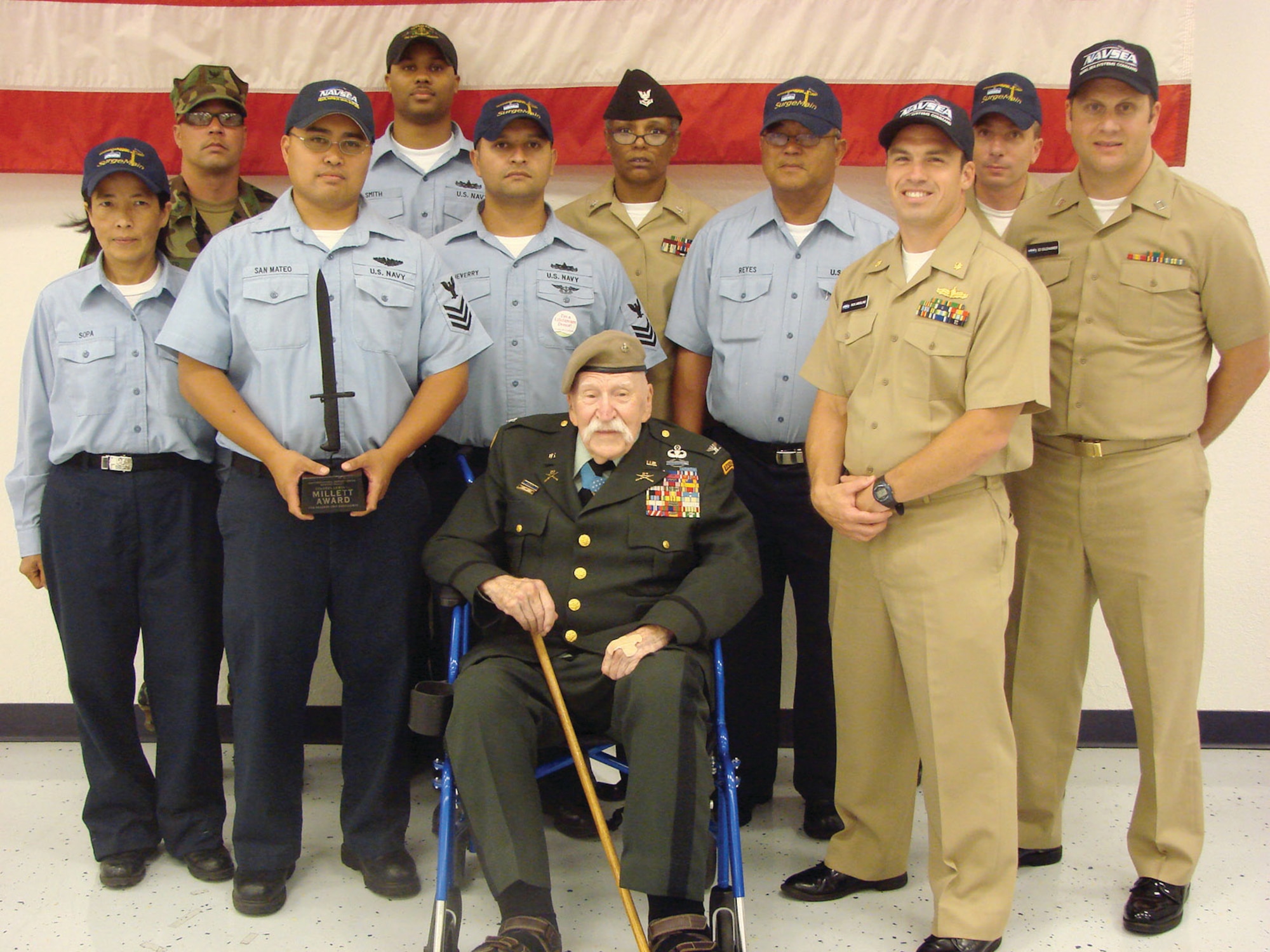 Sailors from Navy Operational Support Center (NOSC) Moreno Valley Surgemain Unit 224 pose with Medal of Honor recipient Col. Lewis Millett after their unit received the first Colonel Millett Unit Excellence Award. (U.S. Navy photo/ Fire Controlman 1st Class Carlos Cruz)