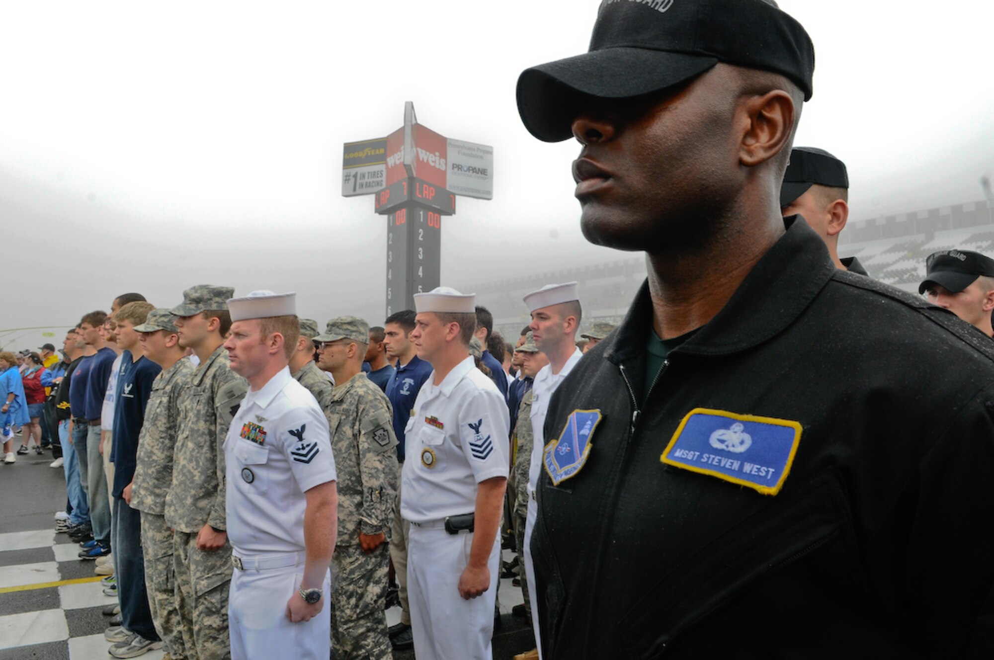 United States Air Force Honor Guard Drill Team stands by as joint service Delayed Enlistment Program members are sworn in by Gen. Norton A. Schwartz, chief of staff of the Air Force, inside the Pocono Motor Raceway Aug. 2 in Pocono, Pa. The DEP is a reserved slot for individuals joining the military as an inactive reserve prior to their set departure date for basic military training. There were more than 100 DEP members from all branches of service, with 23 joining the U.S. Air Force family. (U.S. Air Force photo by Senior Airman Alexandre Montes)