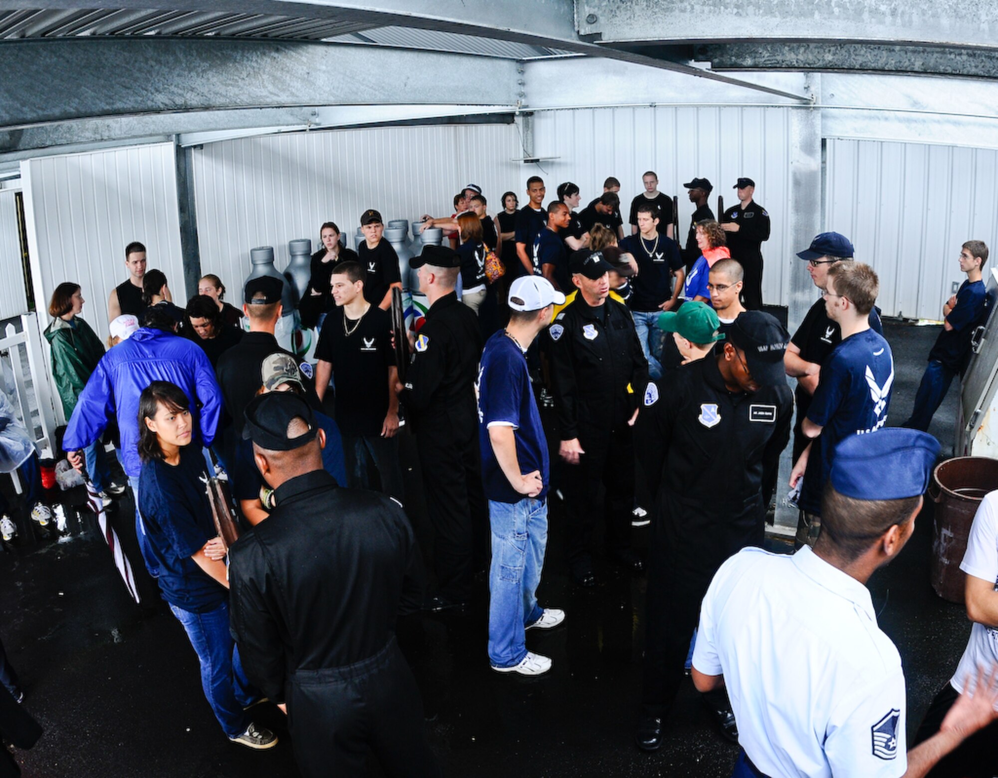 The United States Air Force Honor Guard Drill Team interacts with Delayed Enlistment Program members before they are sworn in by Gen. Norton A. Schwartz, chief of staff of the Air Force, inside the Pocono Motor Raceway Aug. 2 in Pocono, Pa. The DEP is a reserved slot for individuals joining the military as an inactive reserve prior to their set departure date for basic military training. There were more than 100 DEP members from all branches of service, with 23 joining the U.S. Air Force family. (U.S. Air Force photo by Senior Airman Alexandre Montes)