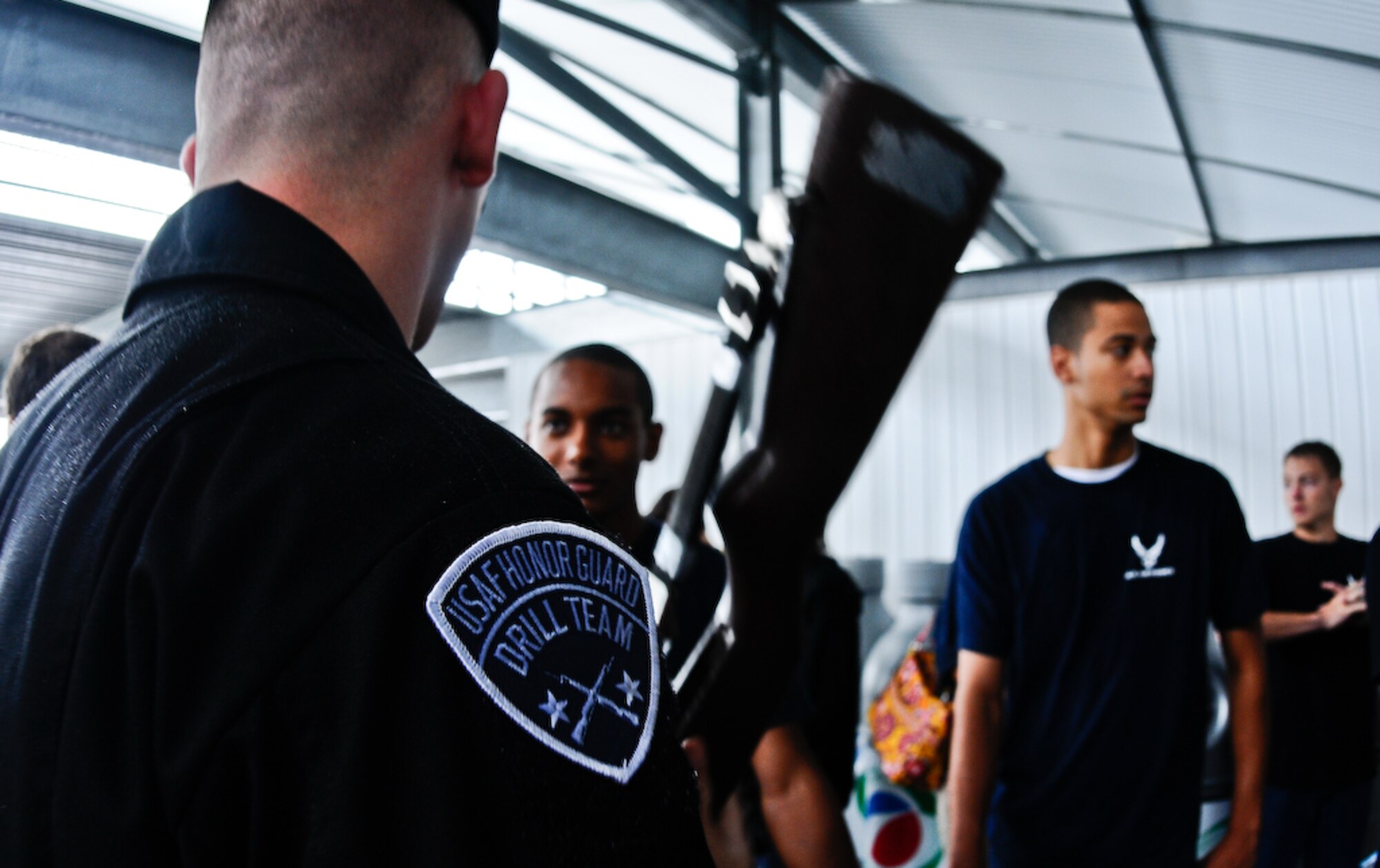 The United States Air Force Honor Guard Drill Team interacts with Delayed Enlistment Program members before they are sworn in by Gen. Norton A. Schwartz, chief of staff of the Air Force, inside the Pocono Motor Raceway Aug. 2 in Pocono, Pa. The DEP is a reserved slot for individuals joining the military as an inactive reserve prior to their set departure date for basic military training. There were more than 100 DEP members from all branches of service, with 23 joining the U.S. Air Force family. (U.S. Air Force photo by Senior Airman Alexandre Montes)