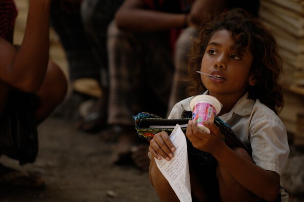 BIKELI, ATAURO – An East Timorese eats her candy and completes some homework while waiting in the registration area prior to being seen by U.S. Air Force and Royal Australian Regiment medical personnel who provided basic medical care by checking vital signs, checking for Malaria, conducting health assessments and distributing antibiotics and Tylenol during a humanitarian visit to the fishing village Bikeli, Atauro, in support of  Pacific Angel on July 21, 2009. Pacific Angel is a 13th Air Force led humanitarian assistance operation aimed at improving military civic cooperation between the United States and Timor Leste.  (U.S.  Air Force photo/Tech Sgt. Cohen A. Young)