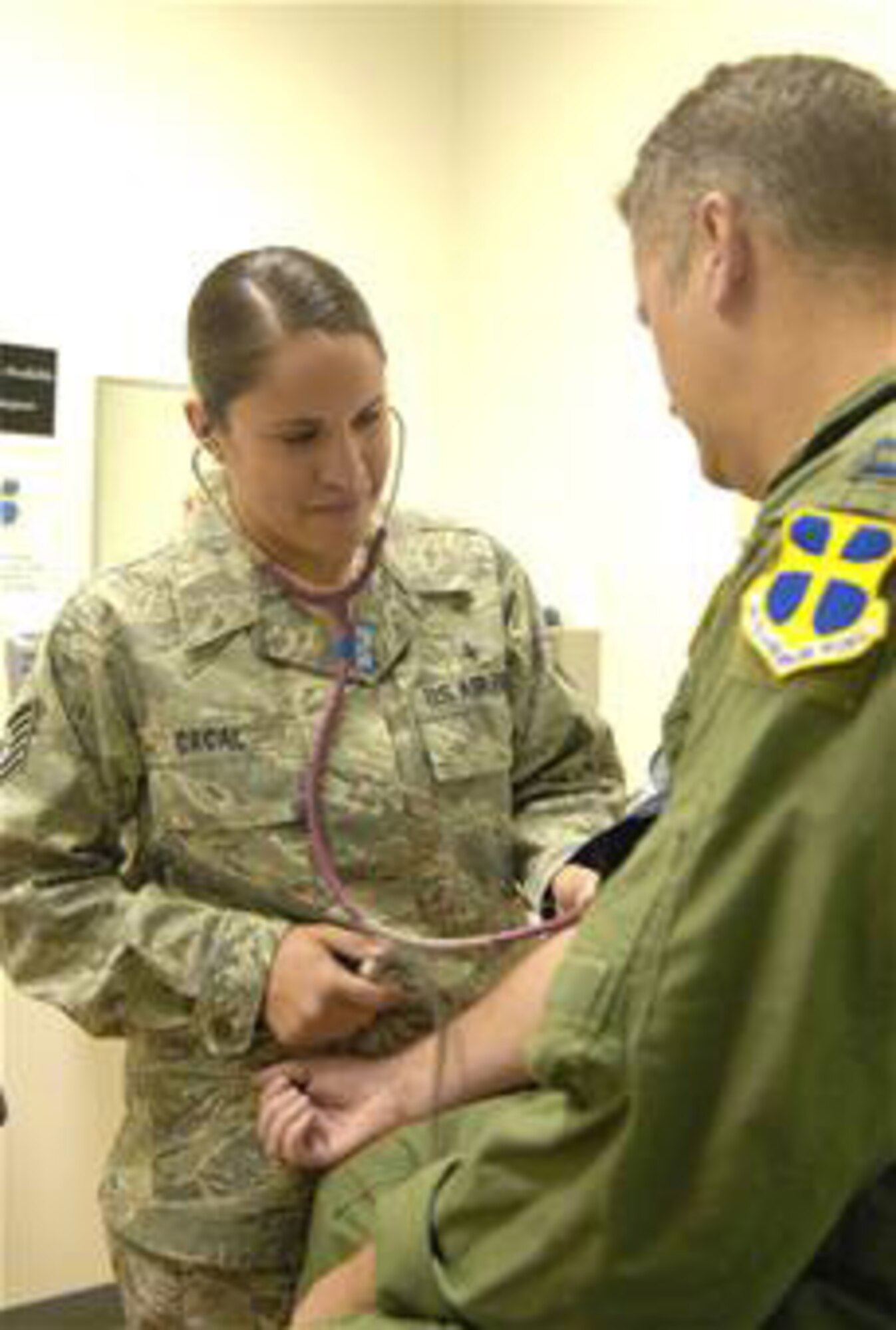 Tech. Sgt. Julianne Cacal checks a patient's blood pressure July 27 at Edwards Air Force Base, Calif.  Sergeant Cacal is a 95th Aerospace Medicine Squadron independent duty medical technician, and diagnoses and treats servicemembers under the license of a supervising doctor. (U.S. Air Force photo/Senior Airman Julius Delos Reyes) 