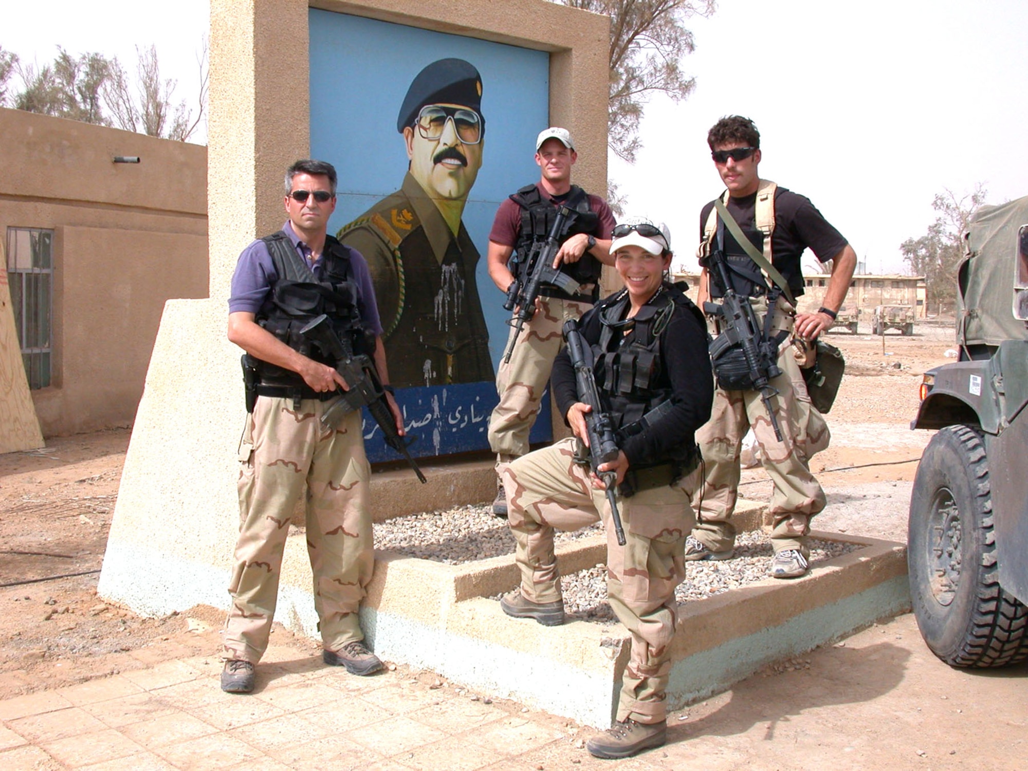 OSI agents provide threat information in dangerous circumstances as they deploy with Air and Space Expeditionary Forces. The four agents in front of the portrait of Saddam Hussein were the first OSI agents in Iraq at the start of the operation. (U.S. Air Force photo)