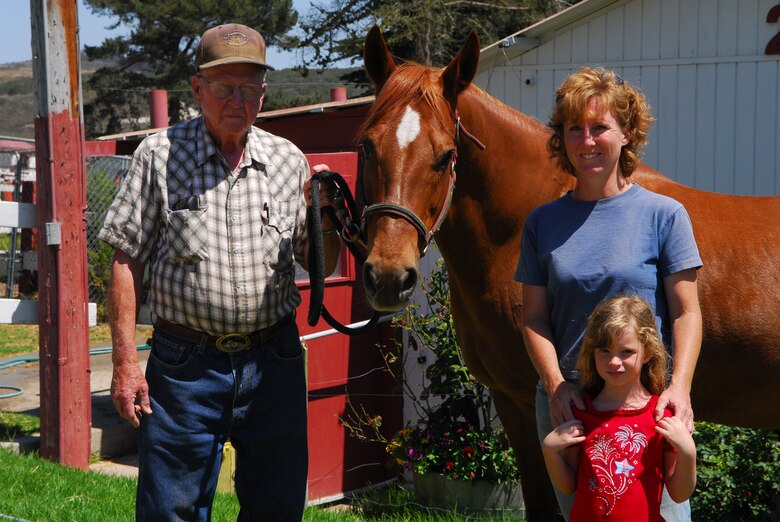 VANDENBERG AIR FORCE BASE, Calif. – Displaying one of his four horses, John Moren, the Vandenberg Saddle Club treasurer, stands with family members, Kelly Moren and Kelsey Moren-Callabresi at the Saddle Club here July 30. The Saddle Club is a members-only club for horse owners. The club features scenic trails for horse riding and 52 individual barns spread out over more than 37 acres of land. (U.S. Air Force photo/Airman 1st Class Steve Bauer)