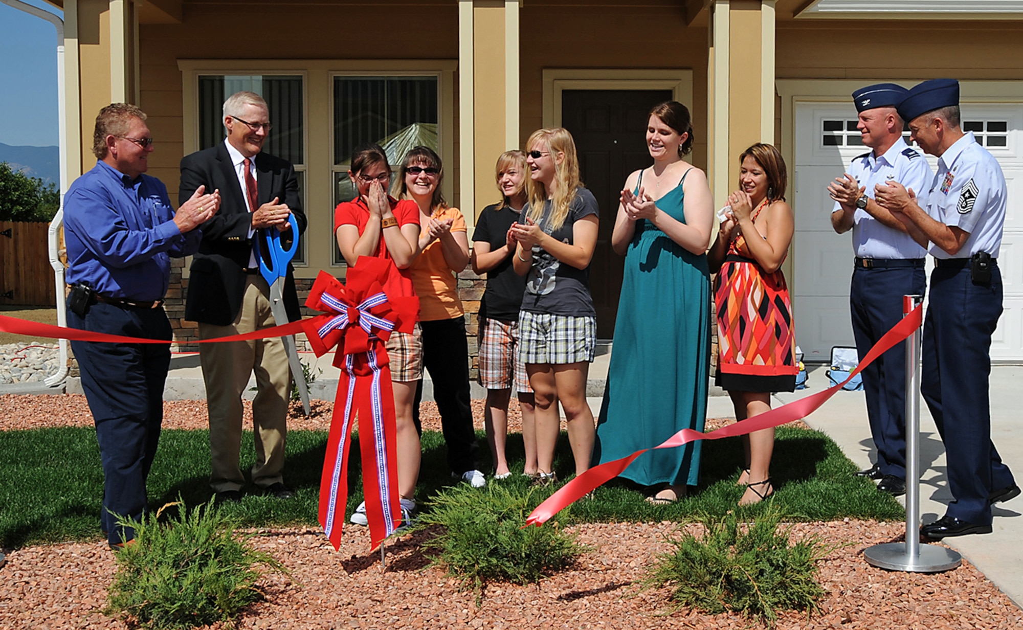Brooke Wincapaw (third from left) reacts after cutting the ribbon to her family’s new home Aug. 3. Brooke’s father, Maj. Troy Wincapaw, is with the 2nd Space Company, an Army unit at Peterson. This recently completed residence is one of 31 “move –in” ready homes of 597 home construction project. Each new energy-efficient residence is 20-to-40 percent larger than Peterson’s old homes, a move designed to greatly improve the quality of life for local servicemembers who resides on base.  (U.S. Air Force photo by Roberta MacDonald)

