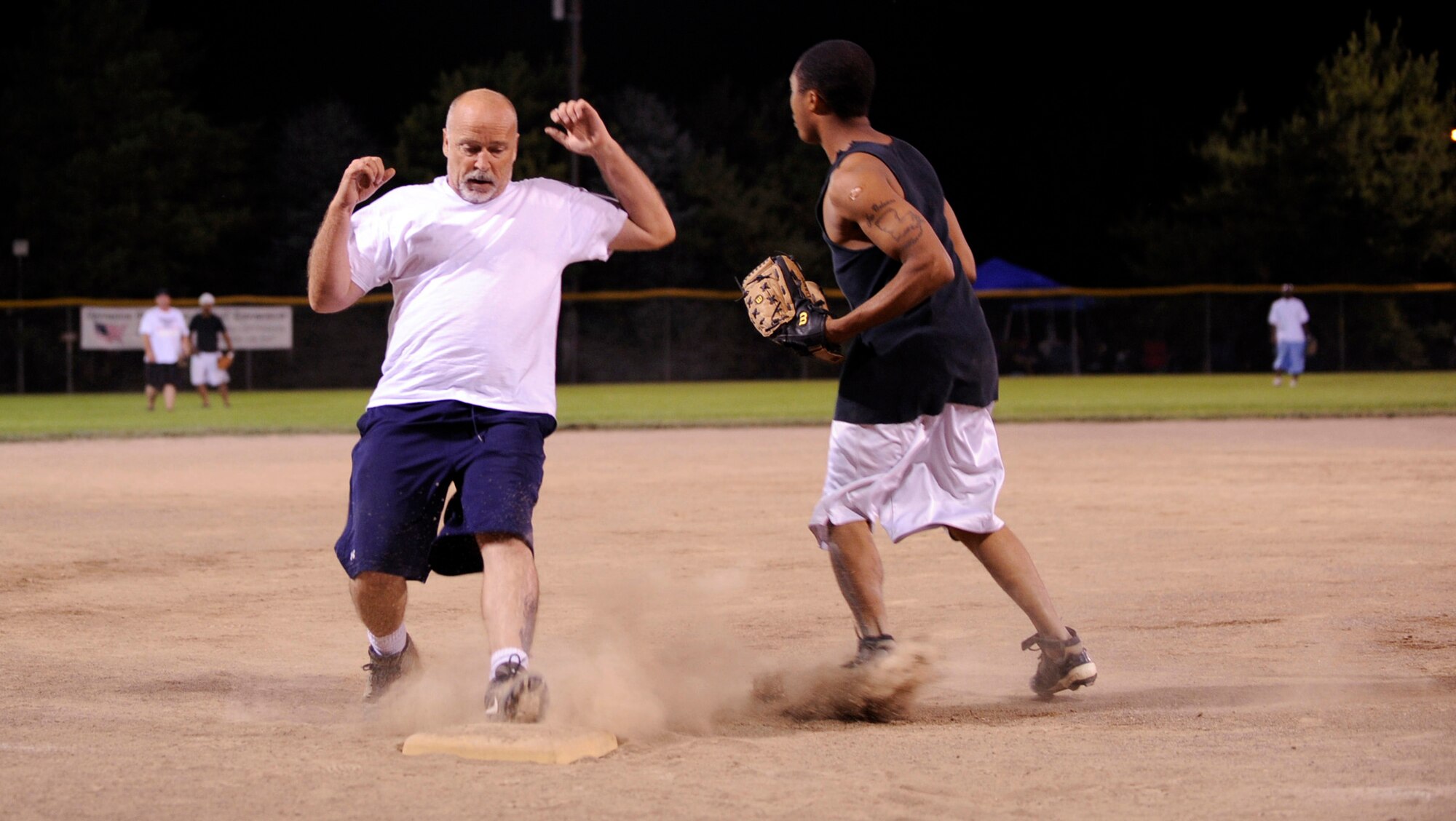 MOUNTAIN HOME AIR FORCE BASE, Idaho -- Robert Fahey, 366th Component Maintenance Squadron second baseman, stops running to third base after Danny Barthelemy, 366th Aircraft Maintenance Squadron third baseman, tagged him out during an Operation Warmheart softball game July 31. AMXS annihilated CMS 19-3. The softball tournament, won by Thrifty's Shake ‘n Bake for the third year in a row, kicked off at 3 p.m. July 31 and ran through Aug. 2 with games played 24 hours a day. Operation Warmheart -- run by the first sergeants council and other committee members -- raises funds to help military families when times get tough financially. (U.S. Air Force photo by Airman 1st Class Debbie Lockhart)