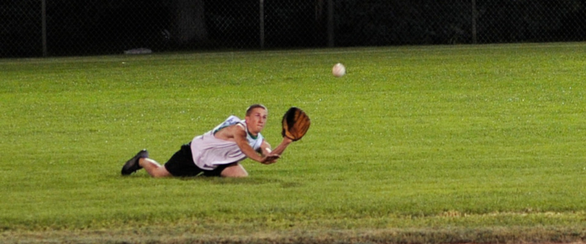 MOUNTAIN HOME AIR FORCE BASE, Idaho -- Michael Campbell, 366th Component Maintenance Squadron left fielder, makes a diving catch to end the fifth inning during an Operation Warmheart softball game July 31. AMXS annihilated CMS 19-3. The softball tournament, won by Thrifty's Shake ‘n Bake for the third year in a row, kicked off at 3 p.m. July 31 and ran through Aug. 2 with games played 24 hours a day. Operation Warmheart -- run by the first sergeants council and other committee members -- raises funds to help military families when times get tough financially. (U.S. Air Force photo by Airman 1st Class Debbie Lockhart)