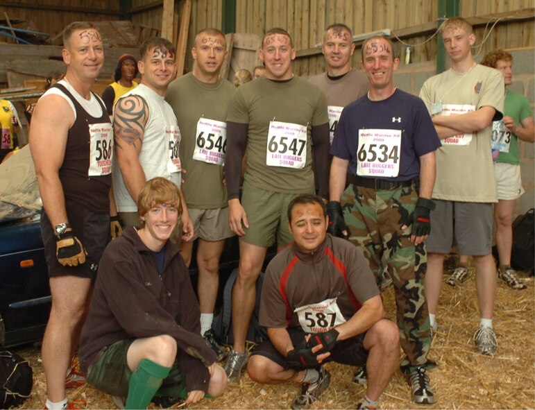 The JAC HAMMERS were among almost 3,000 participants completing a cold and wet UK TOUGH GUY competition on July 25th in ln Old Perton, England. Standing L-R: JAC Commander, Marine Corps Col. Pete Devlin, Marine Sgts. Matthew Johnson, Stacy Jacobs, and Daniel K. Butrim, Navy Master Chief Petty Officer John C. Frakes, Chief Petty Officer Steven Schultz, and Anthony Devlin.  Kneeling are Shane Devlin and LT Jose Lepesuastegui.  (USAF Photo by Staff Sgt. Rachel Goff)