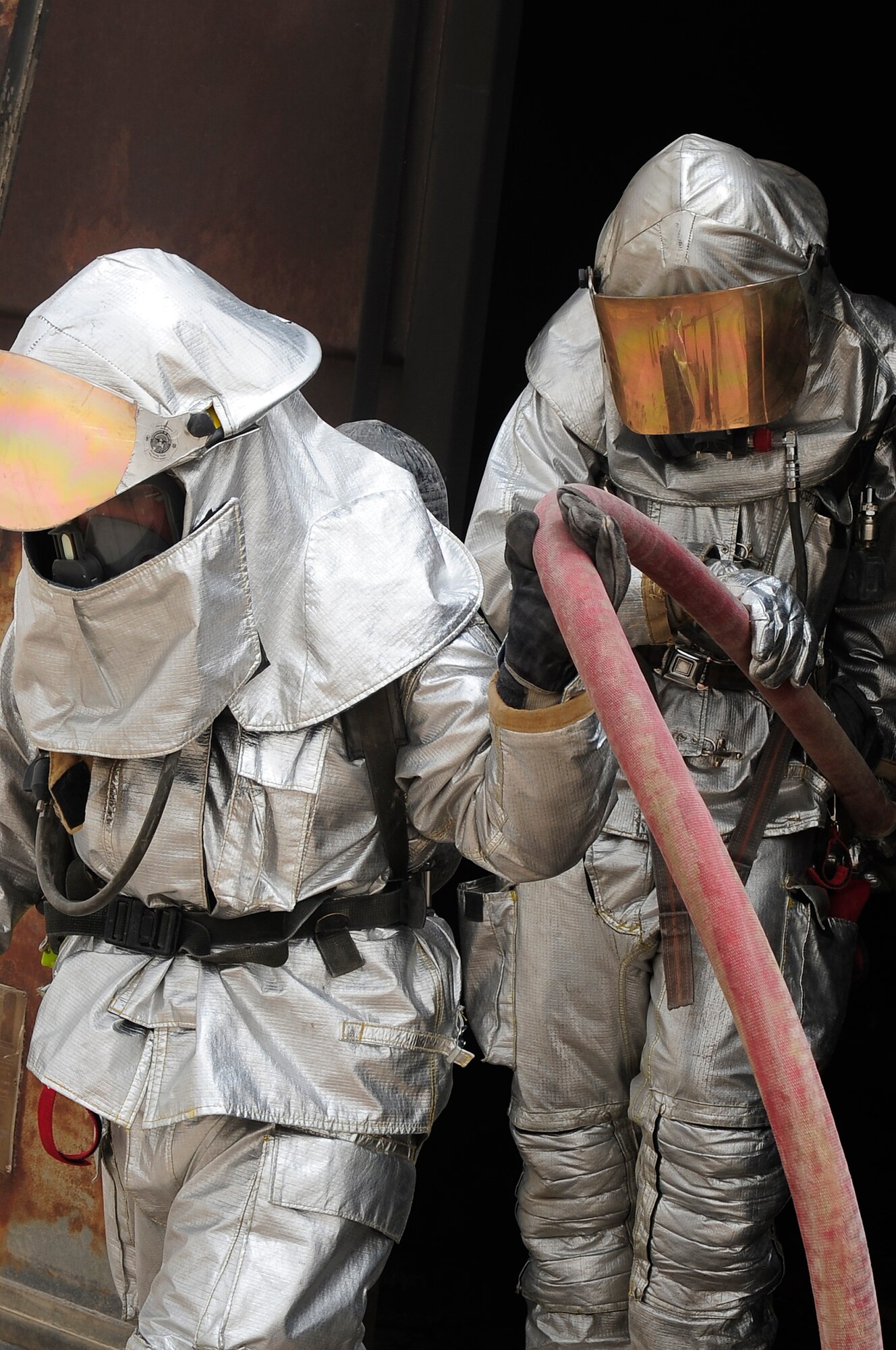 ALI BASE, Iraq - Two Airmen from the 407th Expeditionary Civil Engineer Squadron exit a container express (CONEX) that was set ablaze for the purpose of "live fire" training for Iraqi firefighters from the Dhi Qar province, An Nasiriyah city.  Airmen from the 407th ECES have been mentoring the Iraqi firefighters for six weeks in order to provide them with additional fire response experience and training. (U.S. Air Force photo by Airman 1st Class Tony R. Ritter) 