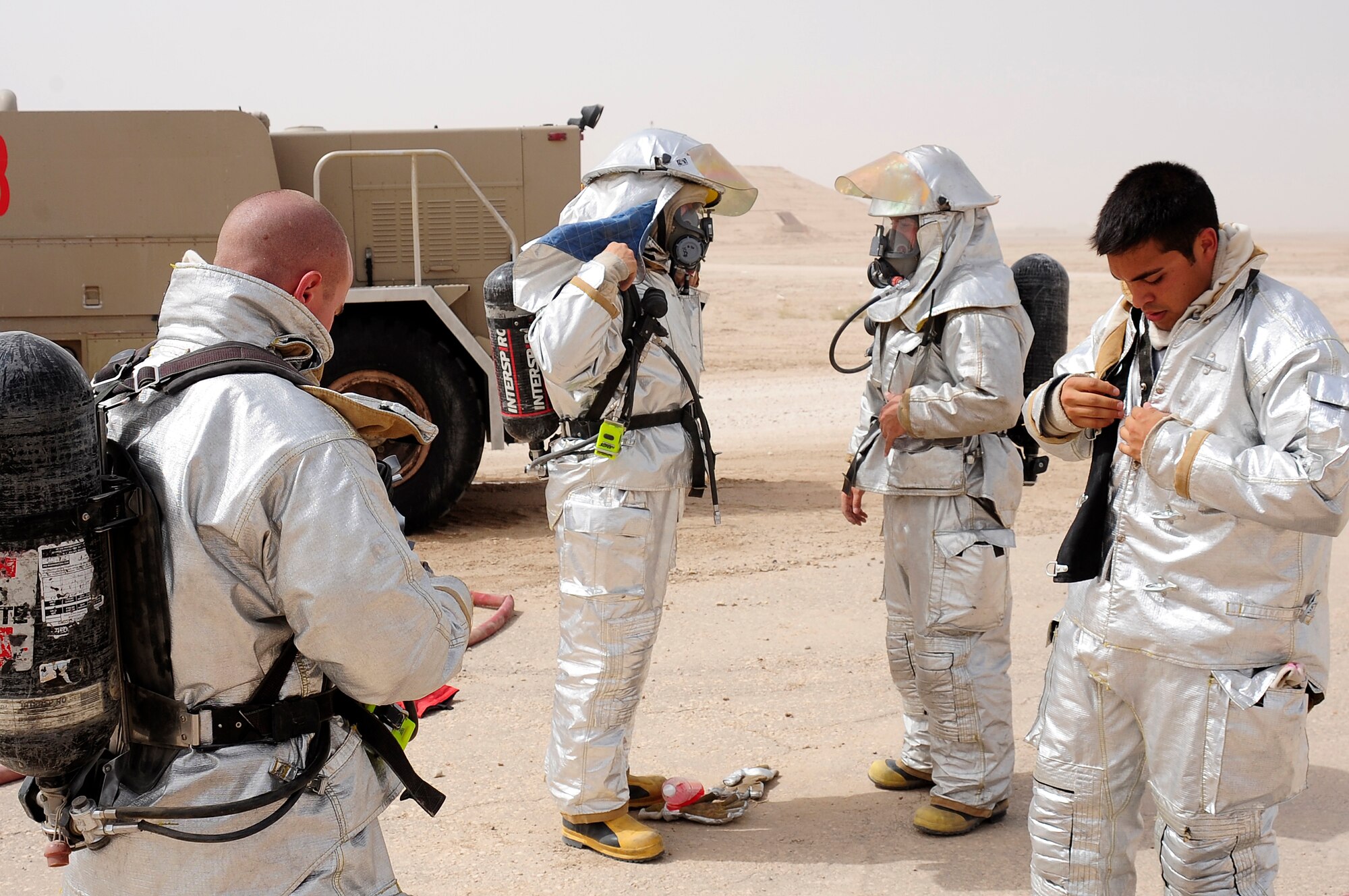 ALI BASE, Iraq - Airmen from the 407th Expeditionary Civil Engineer Squadron suit up prior to training Iraqi firefighters from the Dhi Qar province, An Nasiriyah city.  Airmen from the 407th ECES have been mentoring the Iraqi firefighters for six weeks in order to provide them with additional fire response experience and training.  (from left) Senior Airman Brian Cook, deployed from Eglin AFB, Fla., and Michael Pryor, deployed from Shaw AFB, S.C., and Staff Sgt. John Deese and Abraham Lara, both deployed from Eglin AFB, Fla.  (U.S. Air Force photo by Airman 1st Class Tony R. Ritter)