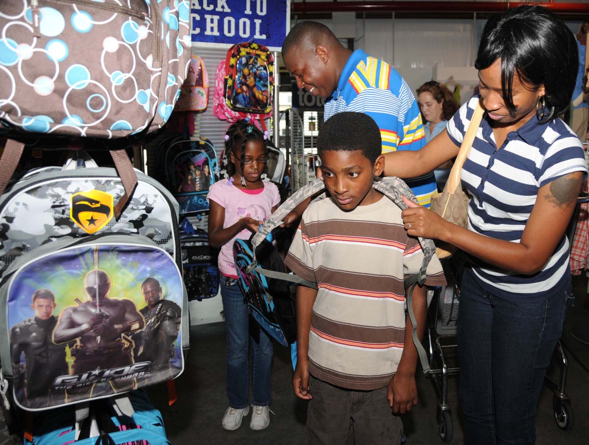 Eight-year-old Summar Hughes and her brother, Herman Hughes, 9, shop for backpacks at the base exchange with their parents, Tech. Sgt. Byron and LaToya Self, 81st Security Forces Squadron.  The children are students at Beauvoir Elementary School in Biloxi.  (U.S. Air Force photo by Kemberly Groue)