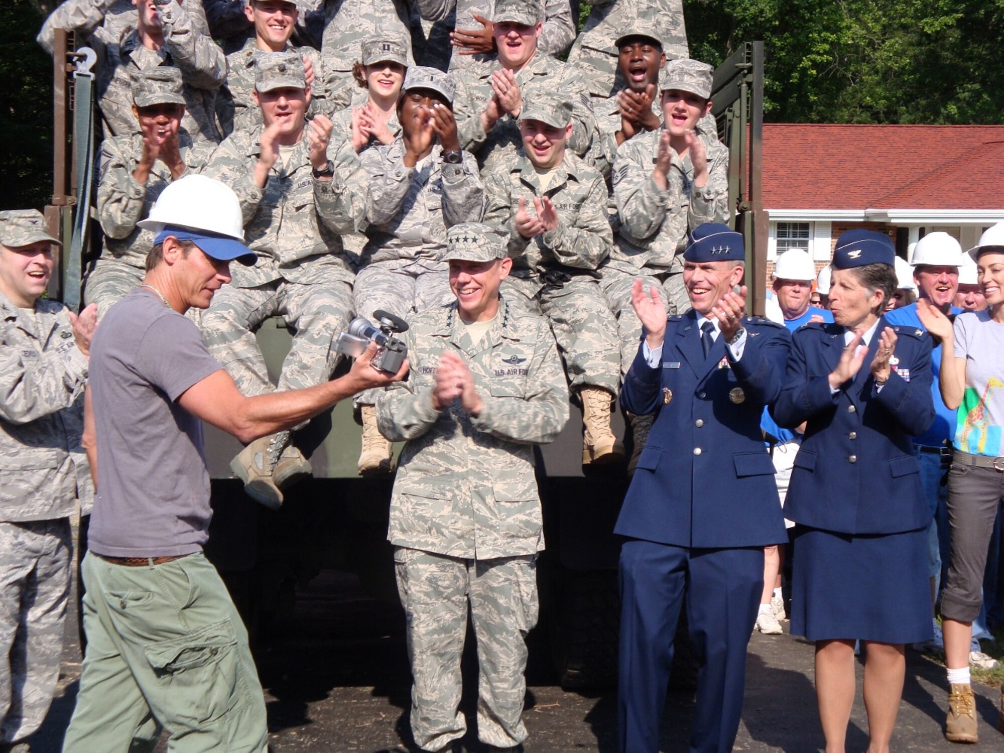 Ty Pennington, star of the ABC series 'Extreme Makeover: Home Edition", used
his "Ty Cam" to interview members of the Air Force team that helped demolish
the family's old home Saturday morning.  At right are Gen. Donald Hoffman,
Lt. Gen Jack Hudson and retired Col. Sue Busler.  
(Air Force photo by Ron Fry)